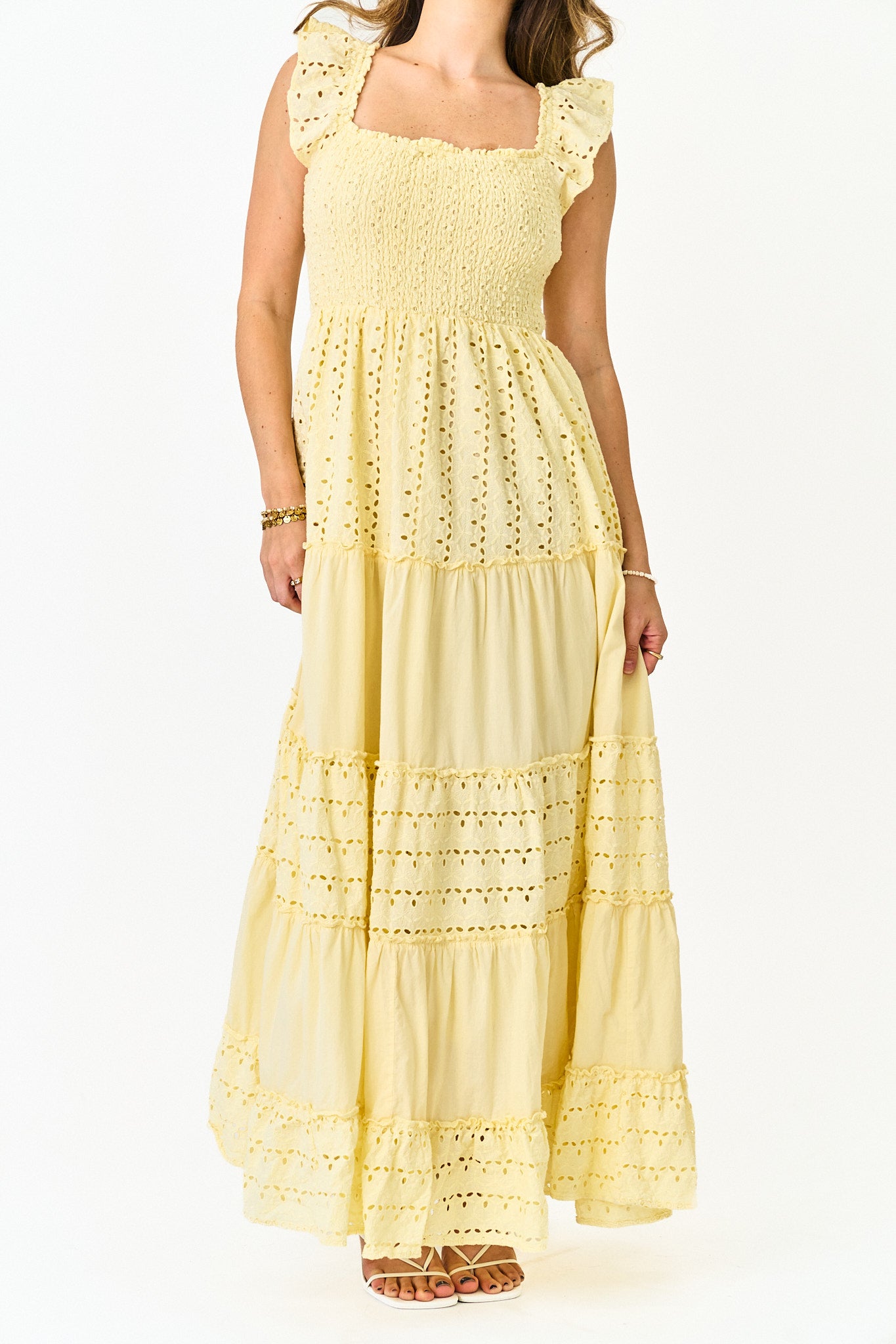 Woman wearing a yellow lace dress on a white background