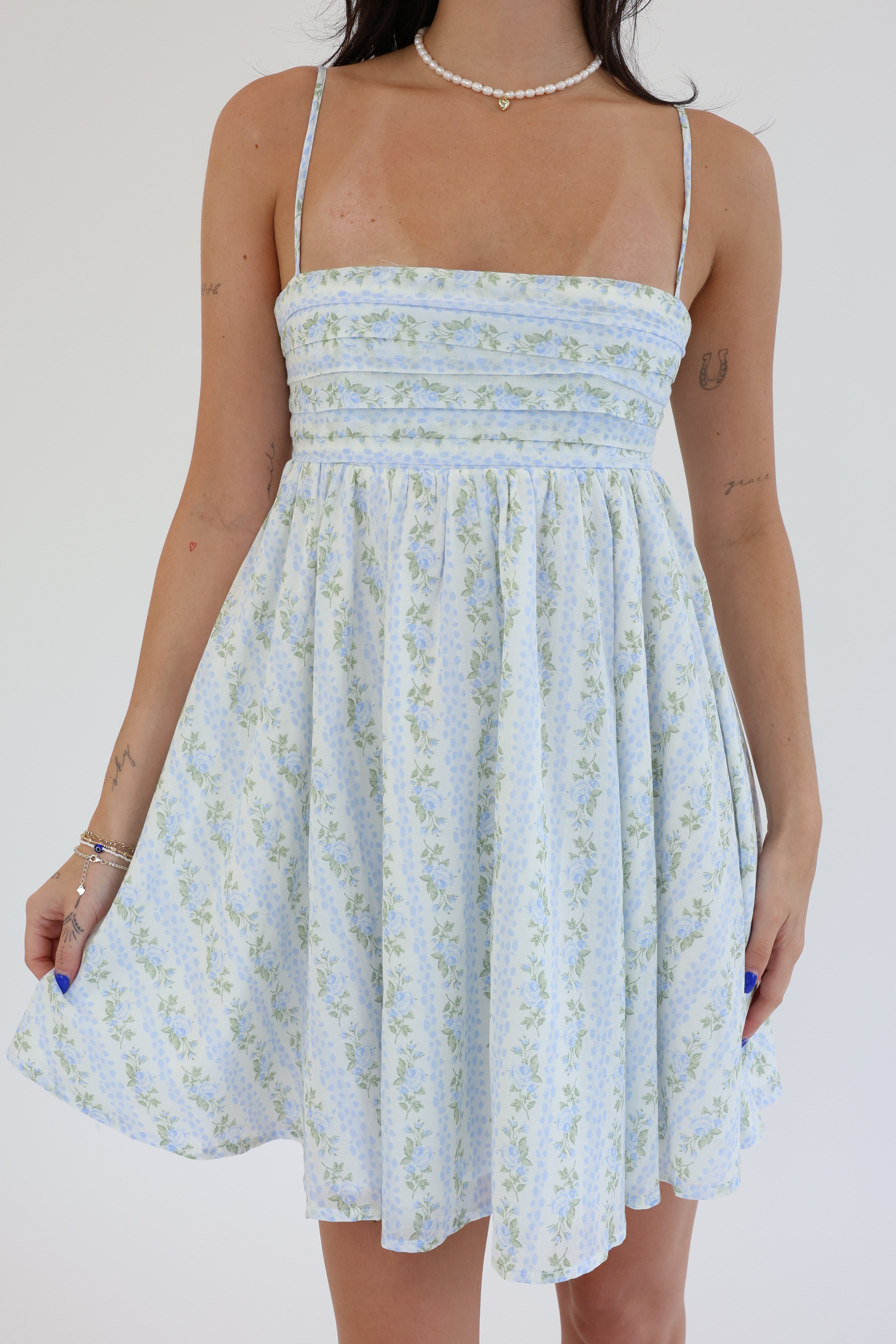 Light blue floral dress worn by a person on a white background