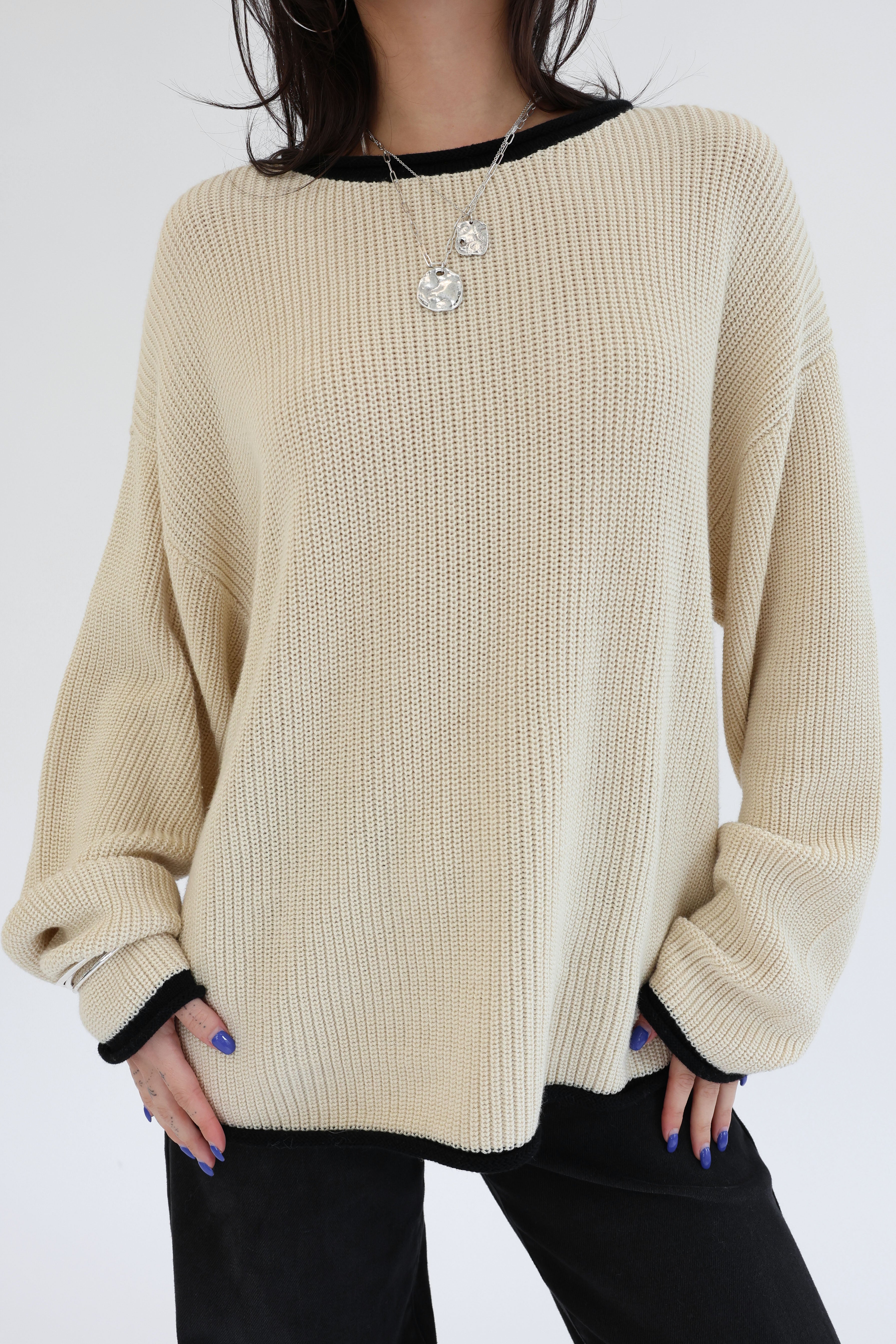 Beige sweater worn by a person on a white background