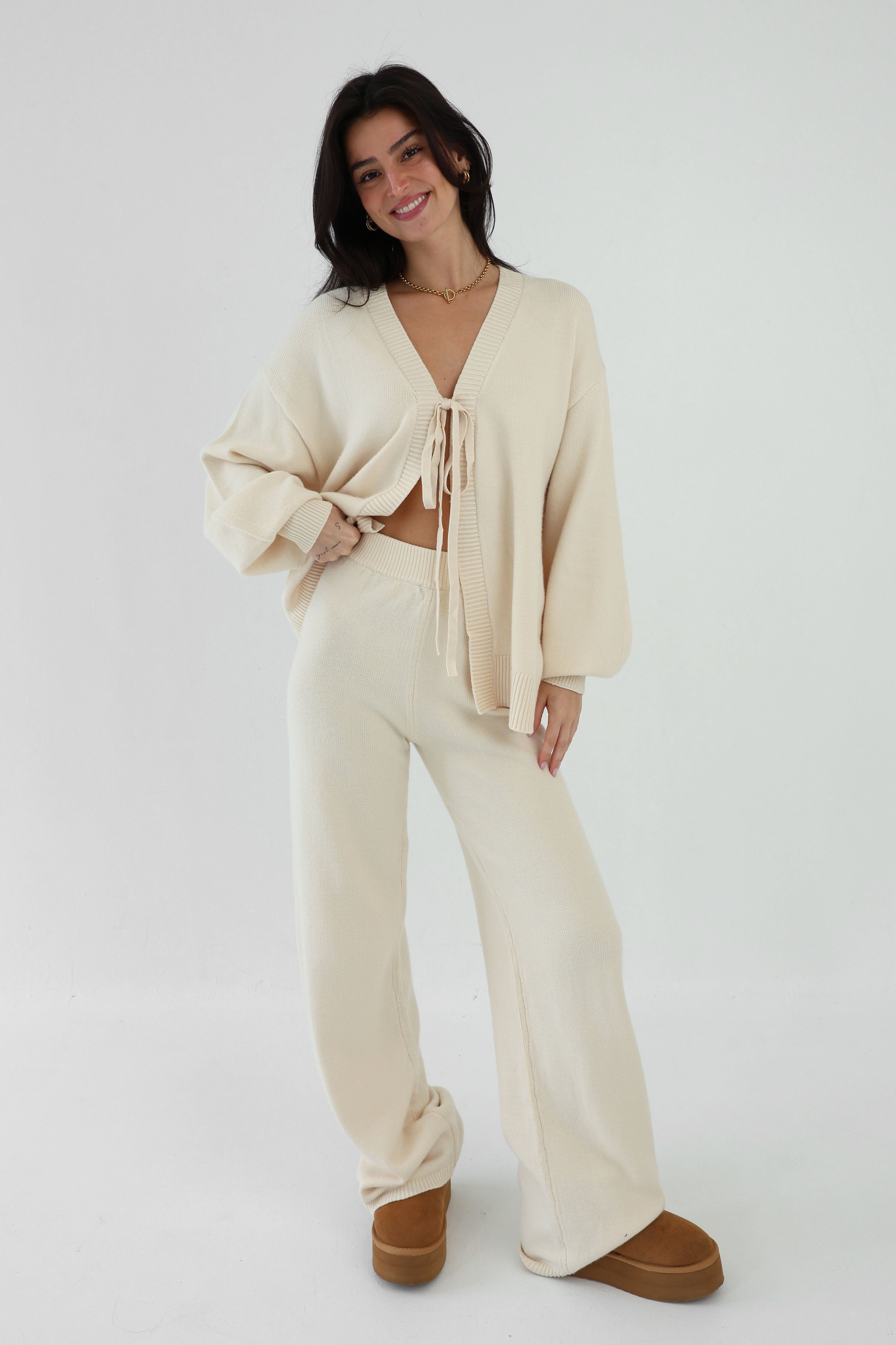 Woman wearing a beige outfit with a white background