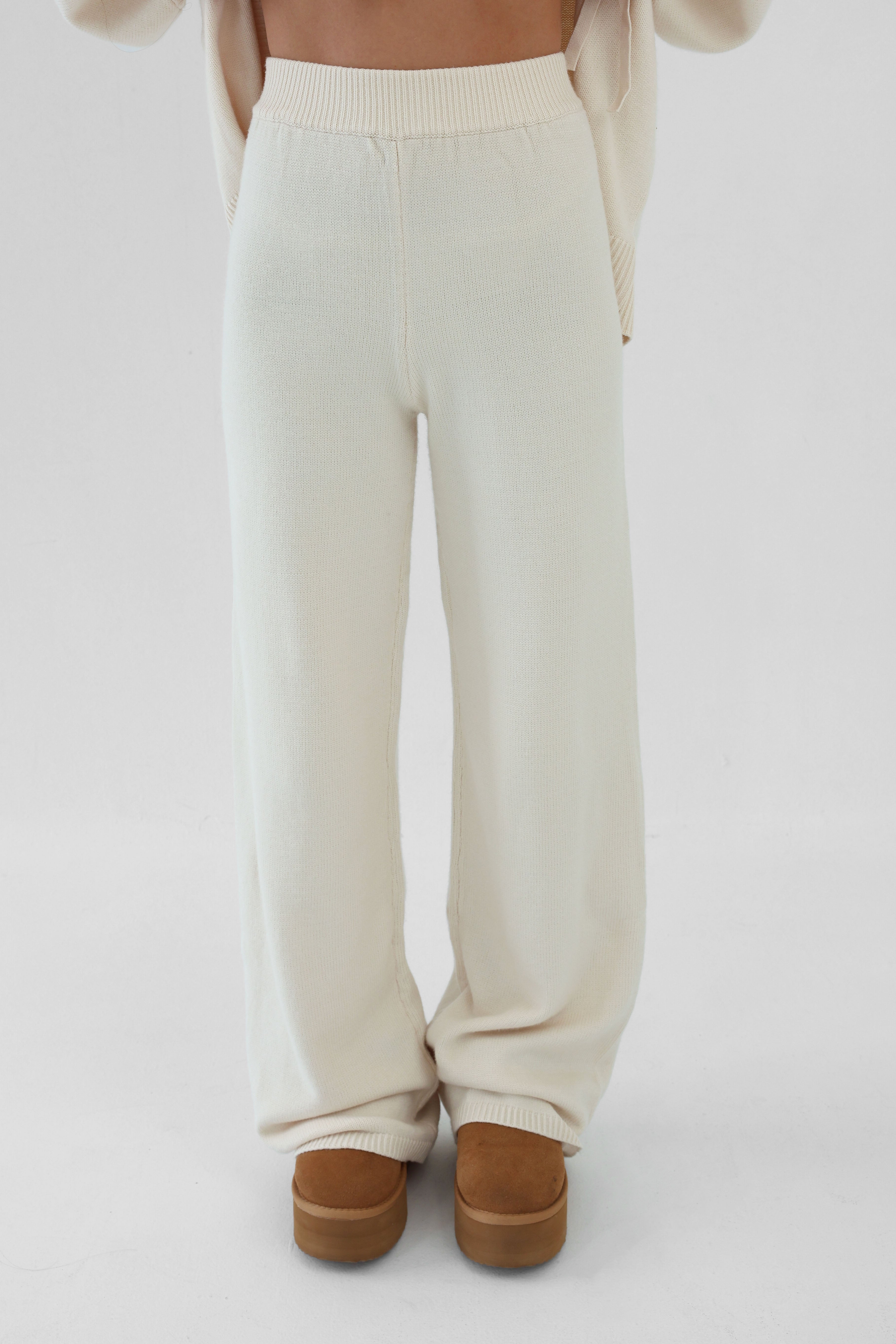 White pants worn by a person on a white background