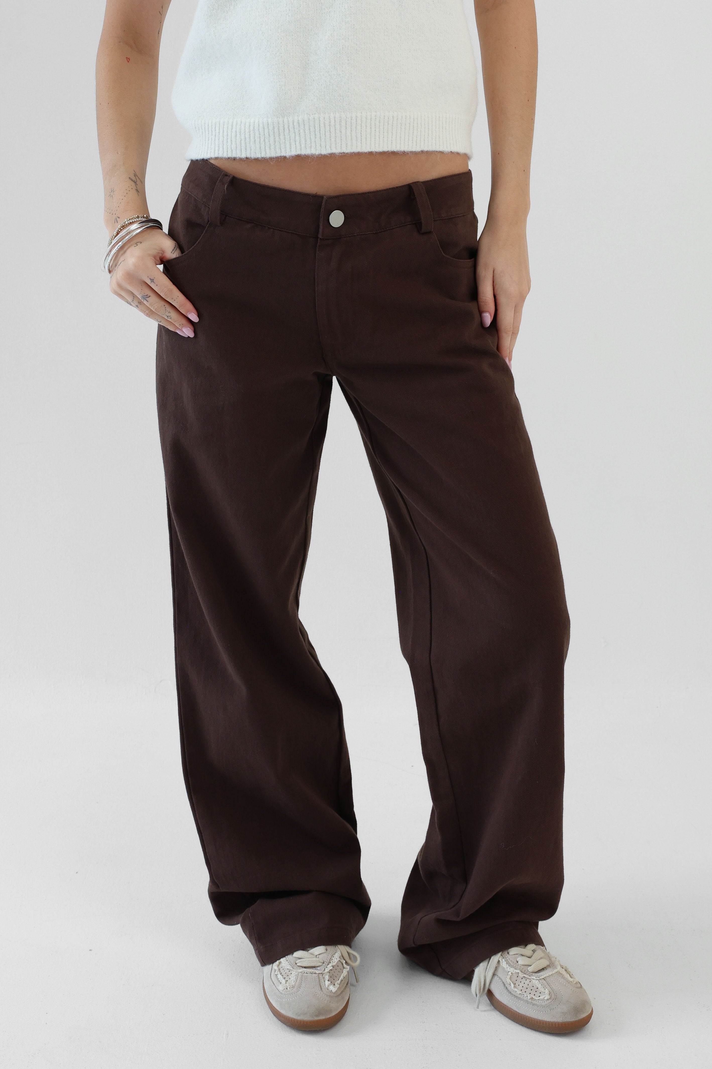 Brown pants worn by a person on a white background