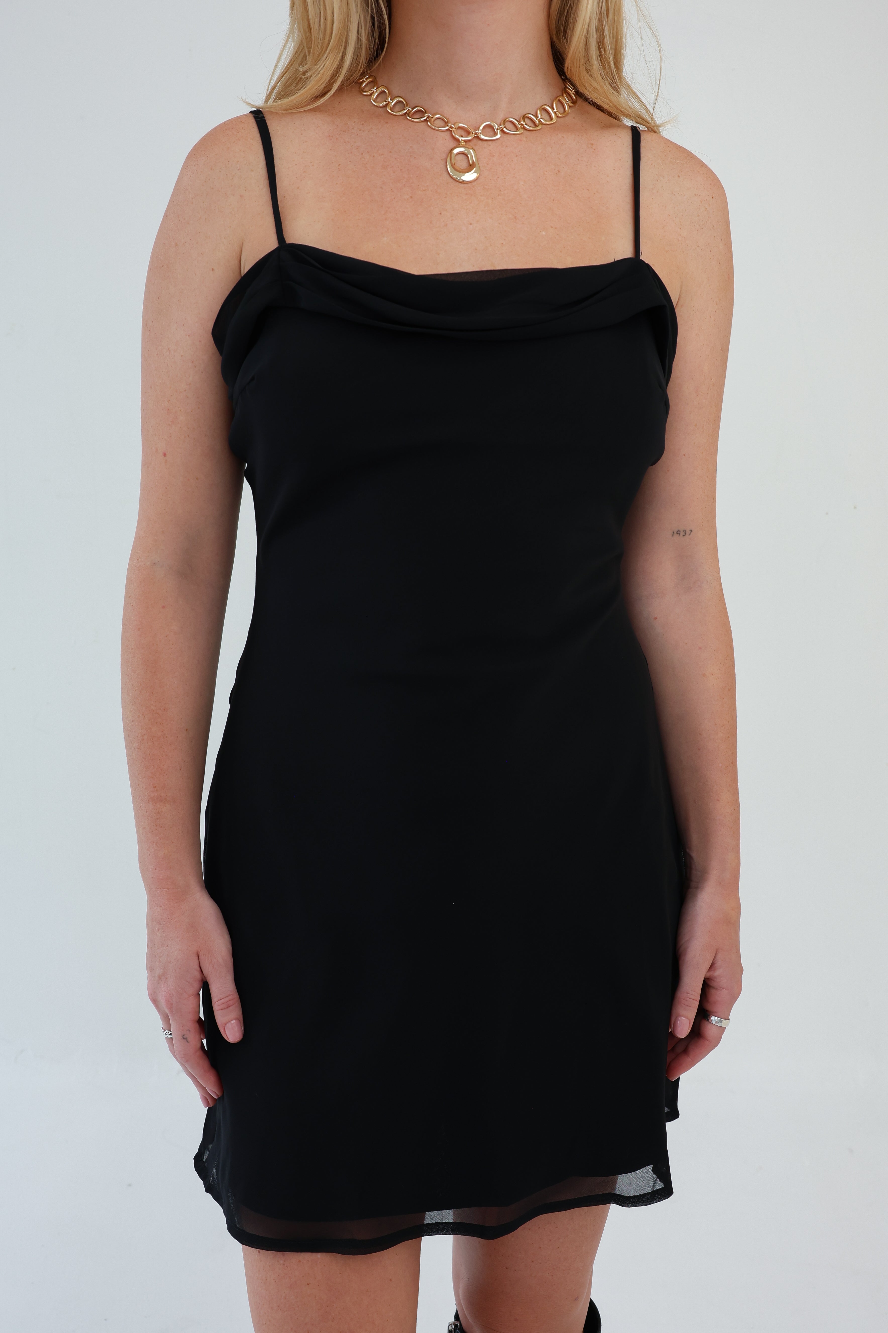 Black dress worn by a person on a white background