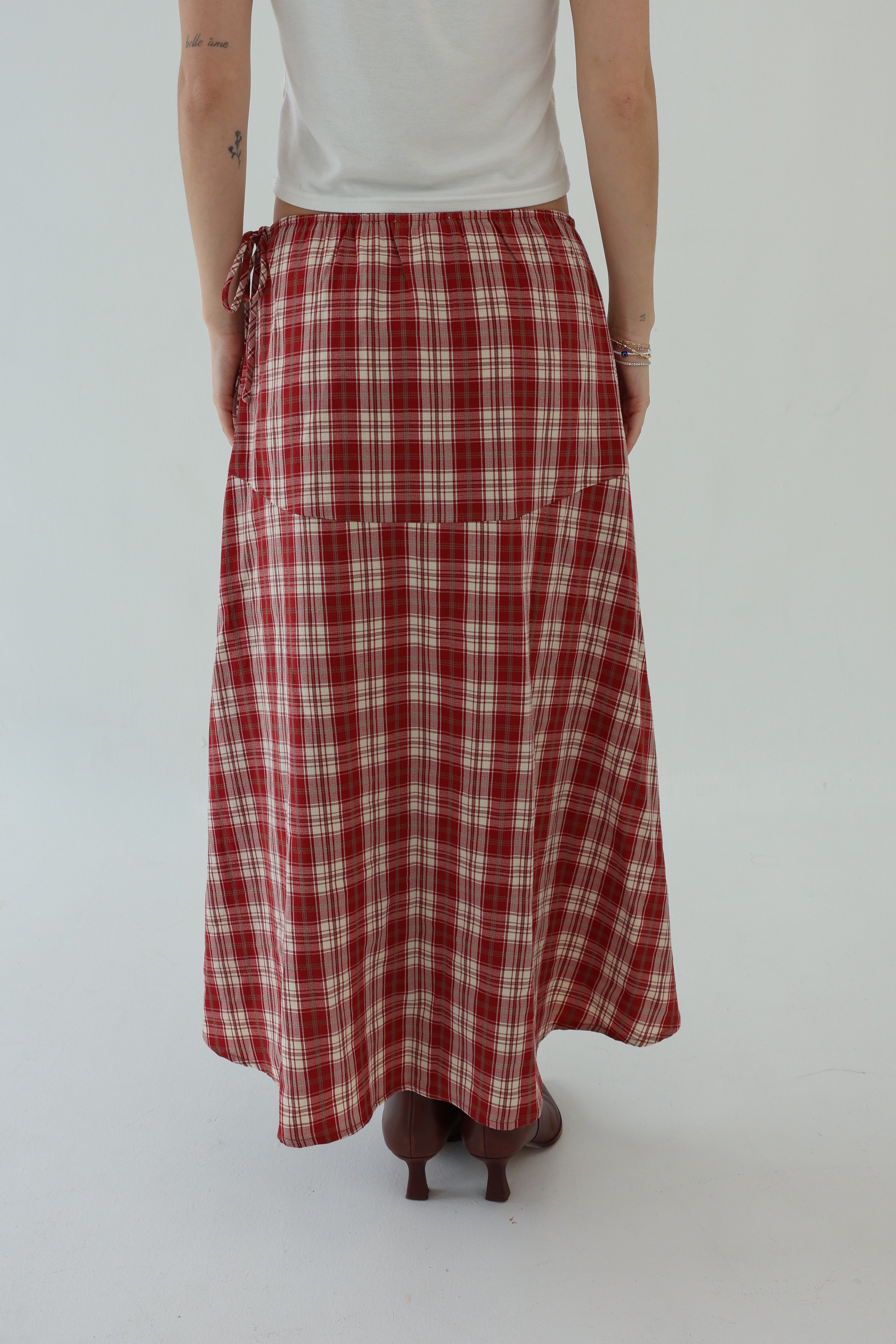 Person wearing a red plaid skirt on a white background