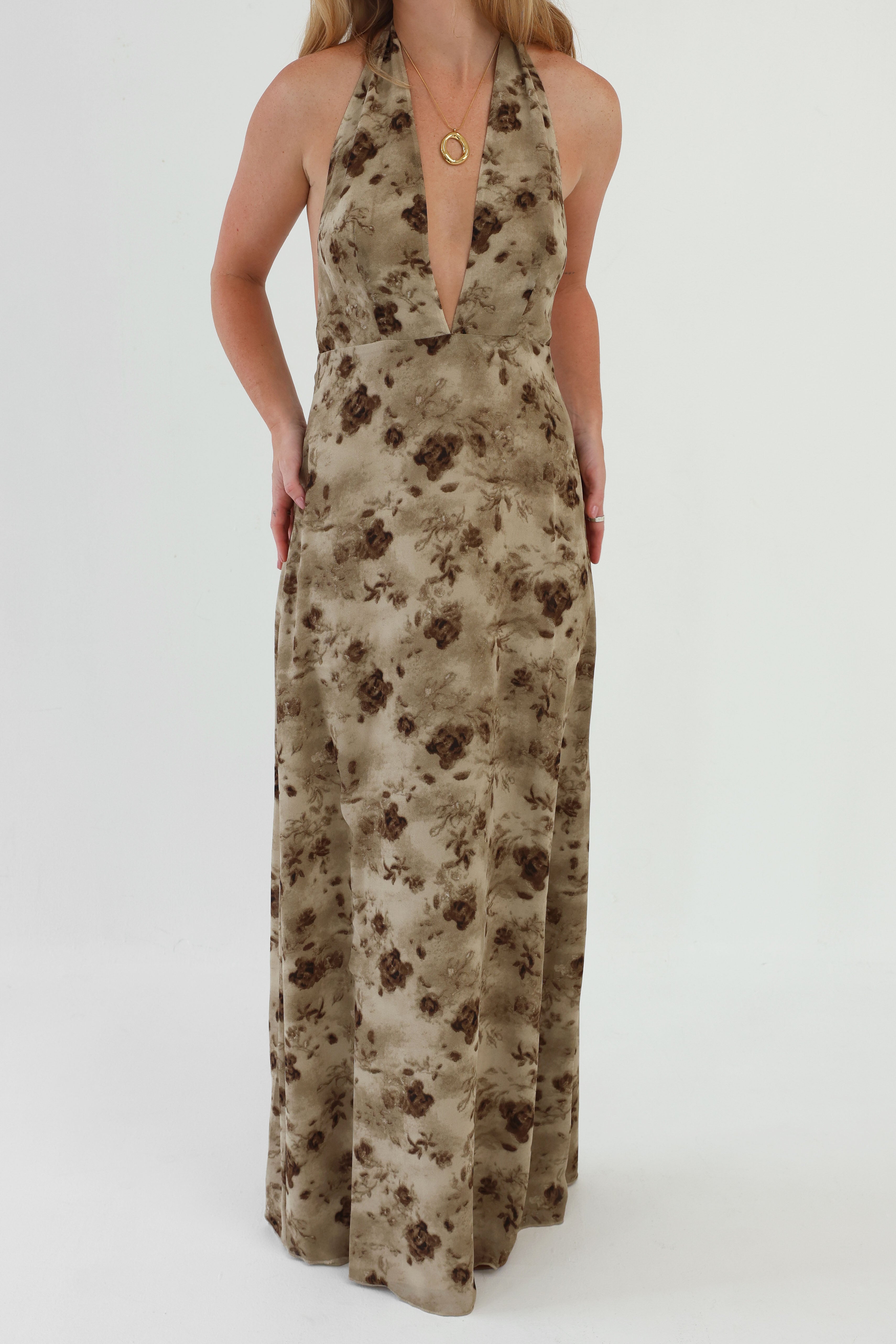 Woman wearing a floral halter neck dress on a white background