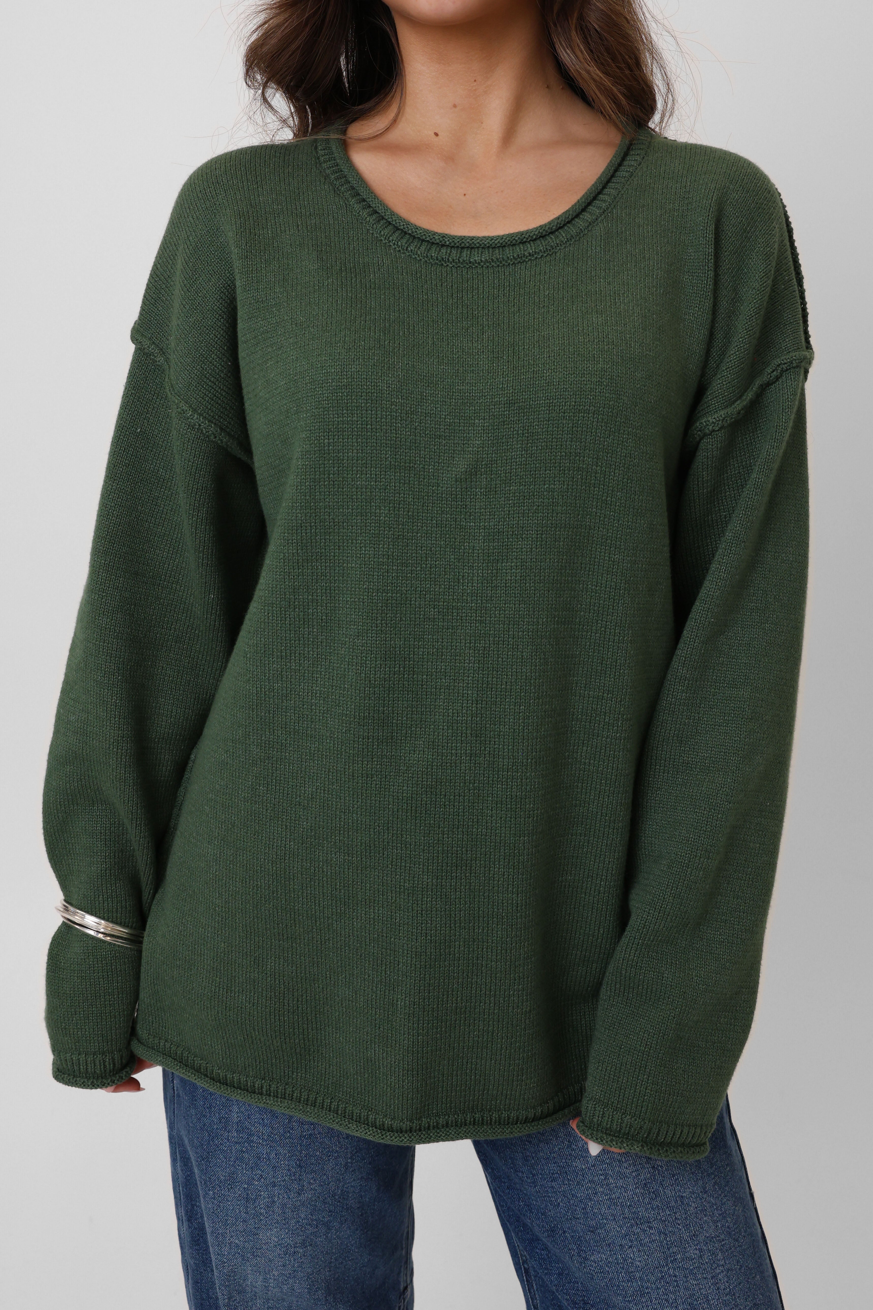 Green sweater worn by a person on a plain background