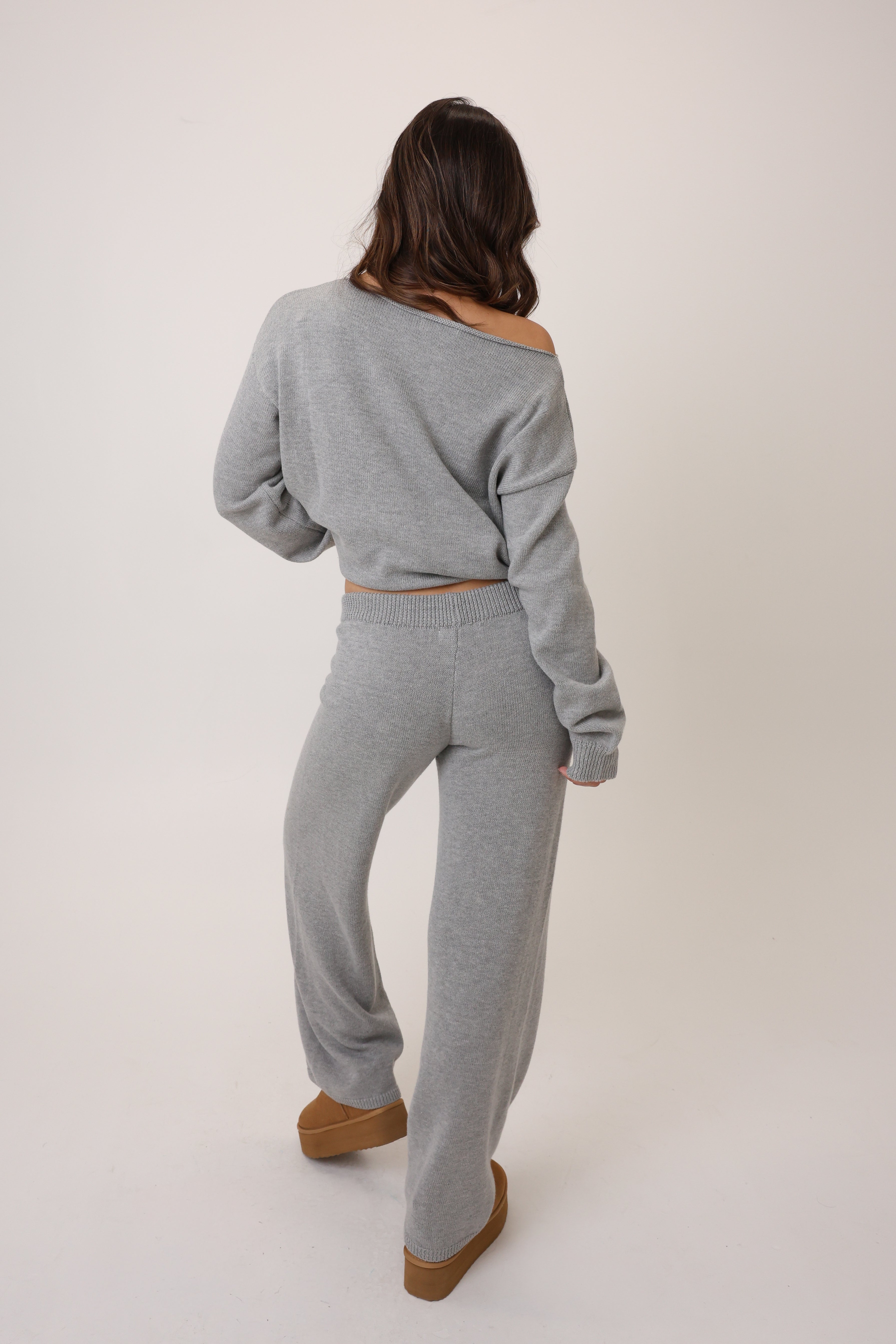 Person wearing a gray outfit with a plain background