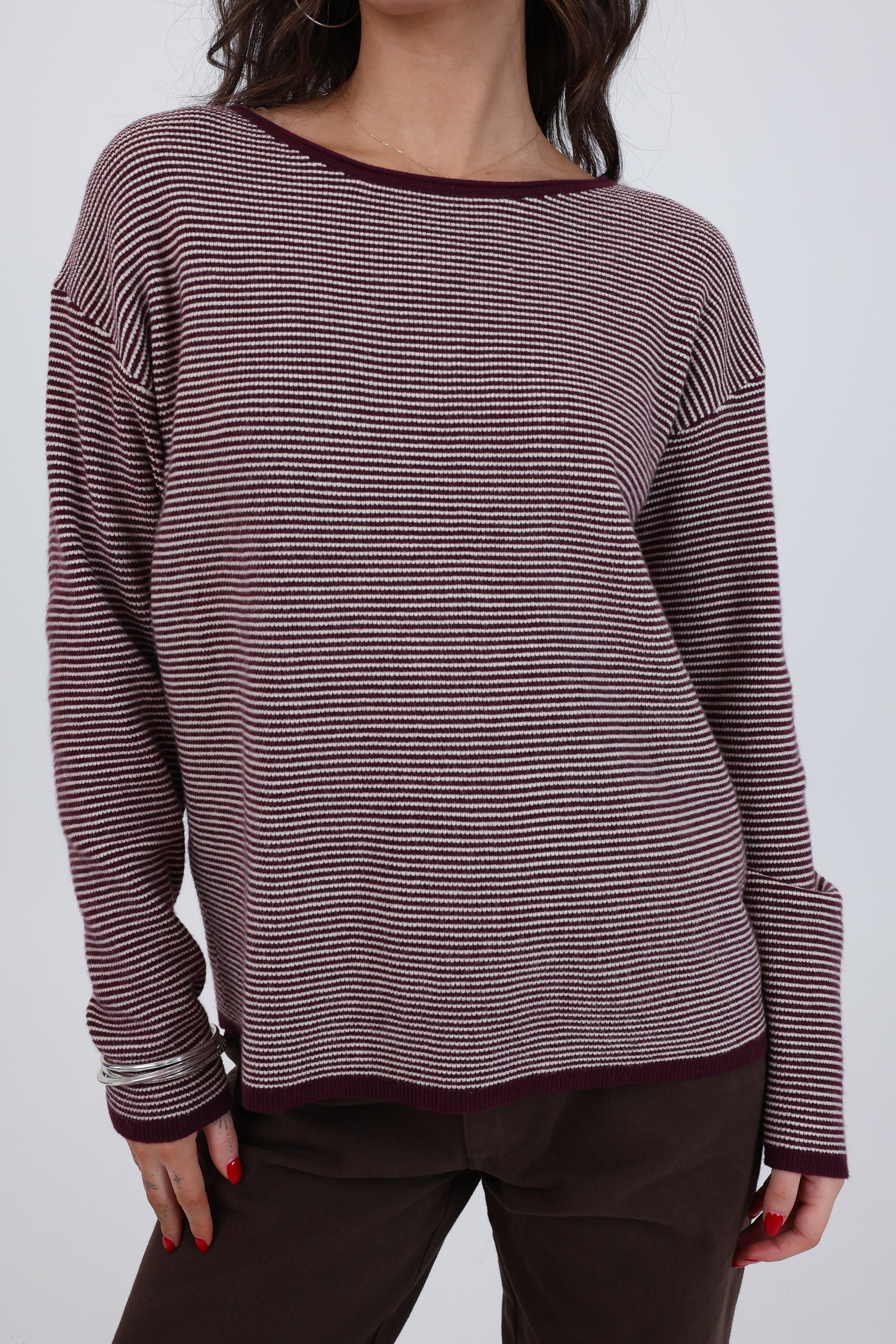 Striped long-sleeve top worn by a person on a plain background