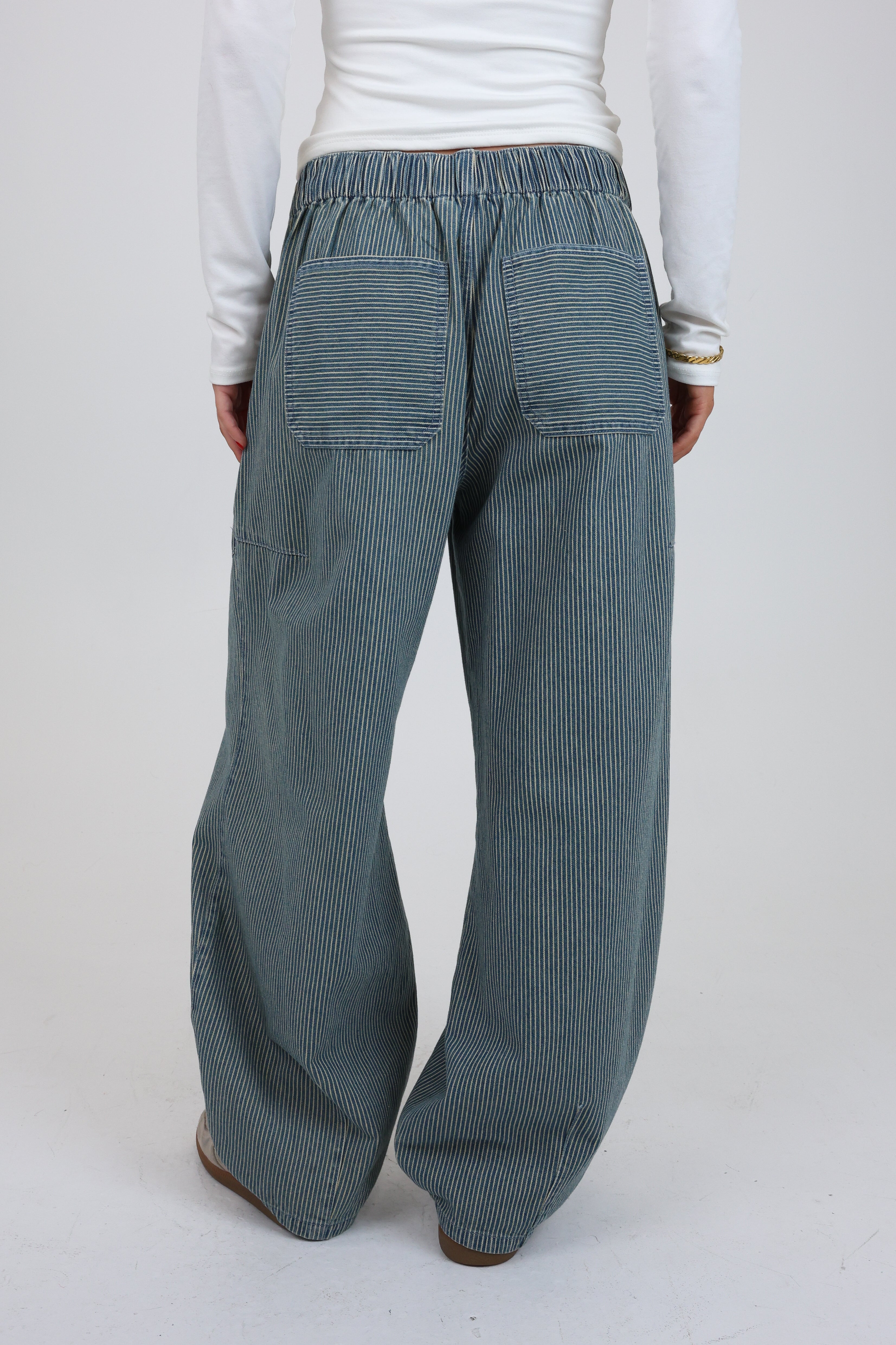 Person wearing blue striped pants on a white background