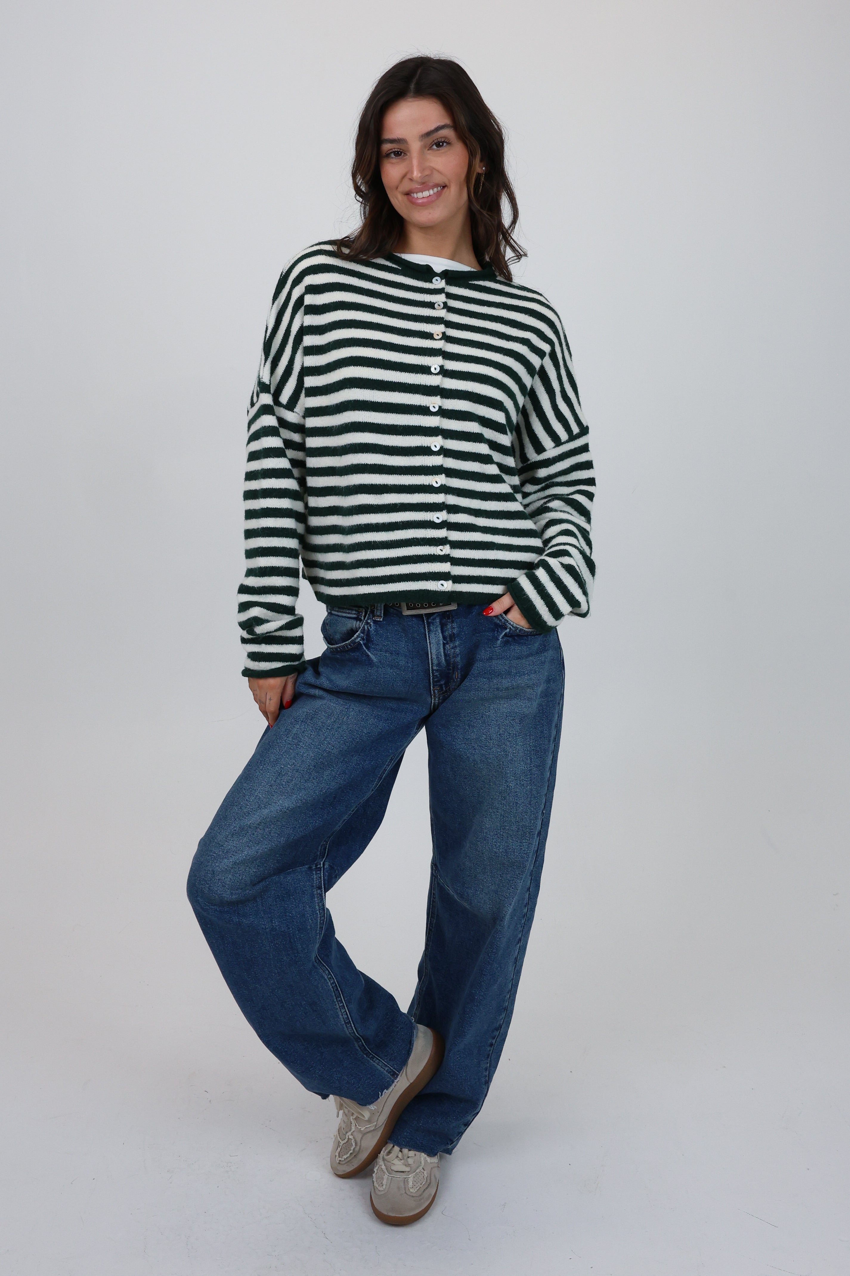 Woman wearing a black and white striped shirt and blue jeans on a white background