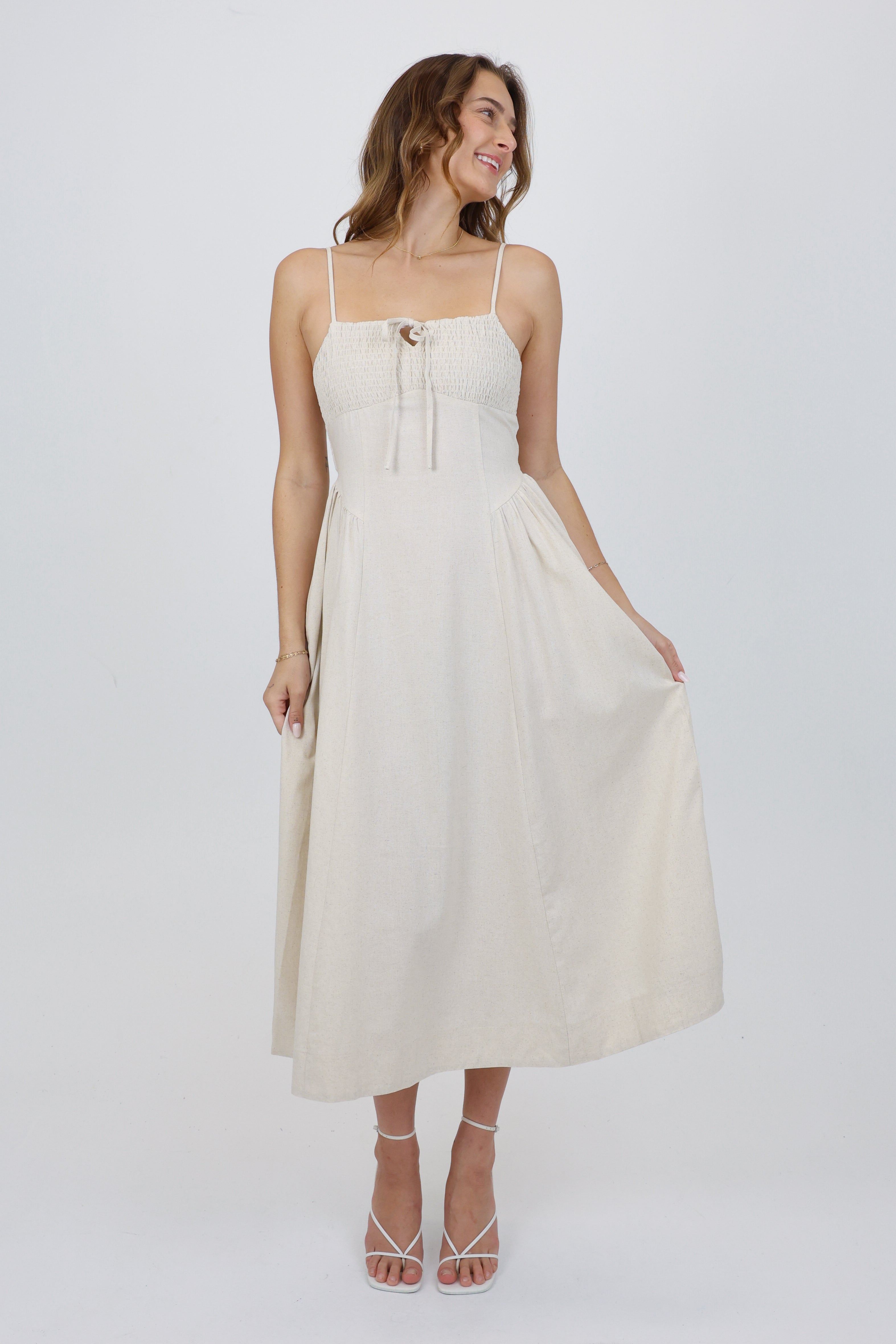 Woman wearing a white dress on a plain background