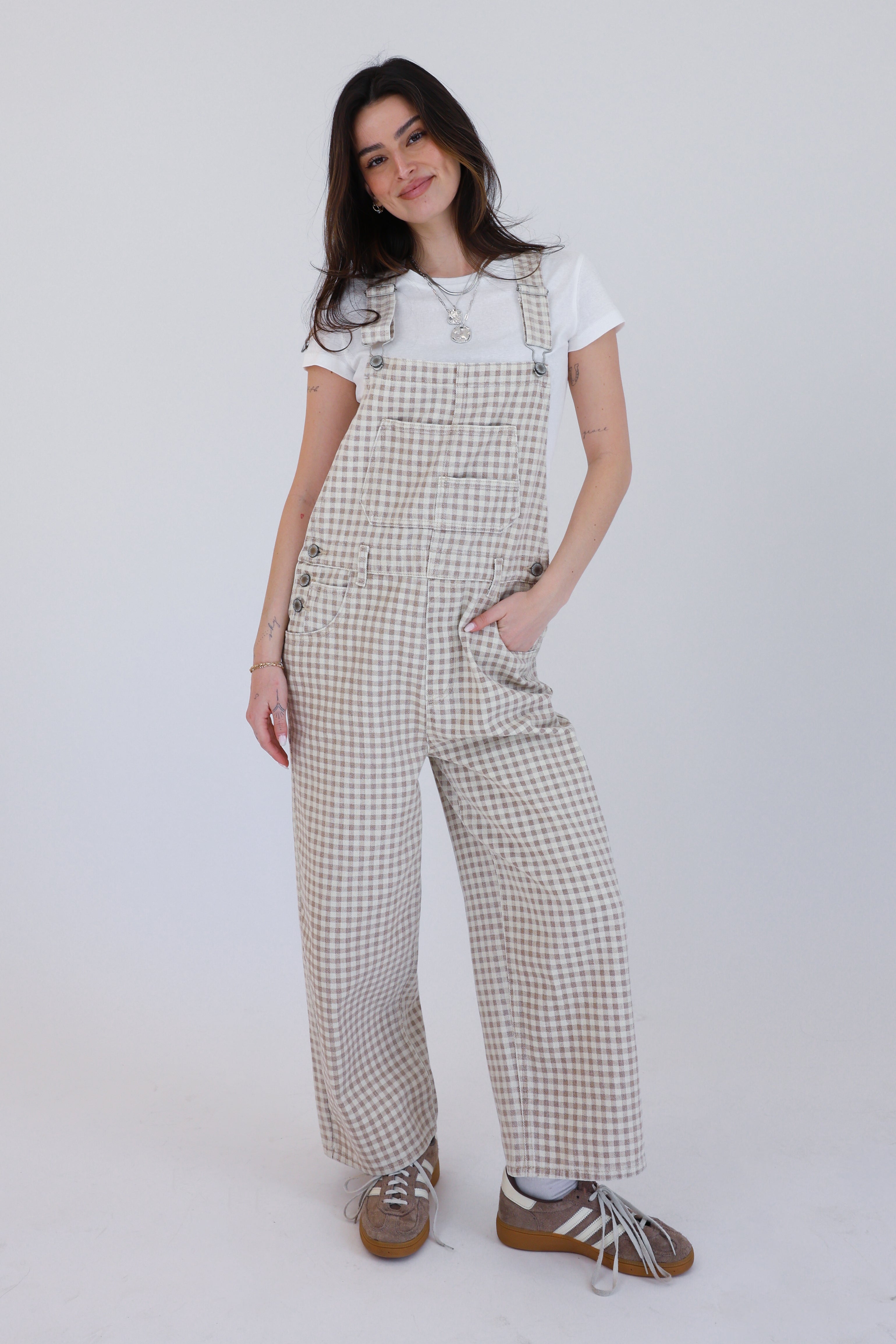 Woman wearing checkered overalls on a white background