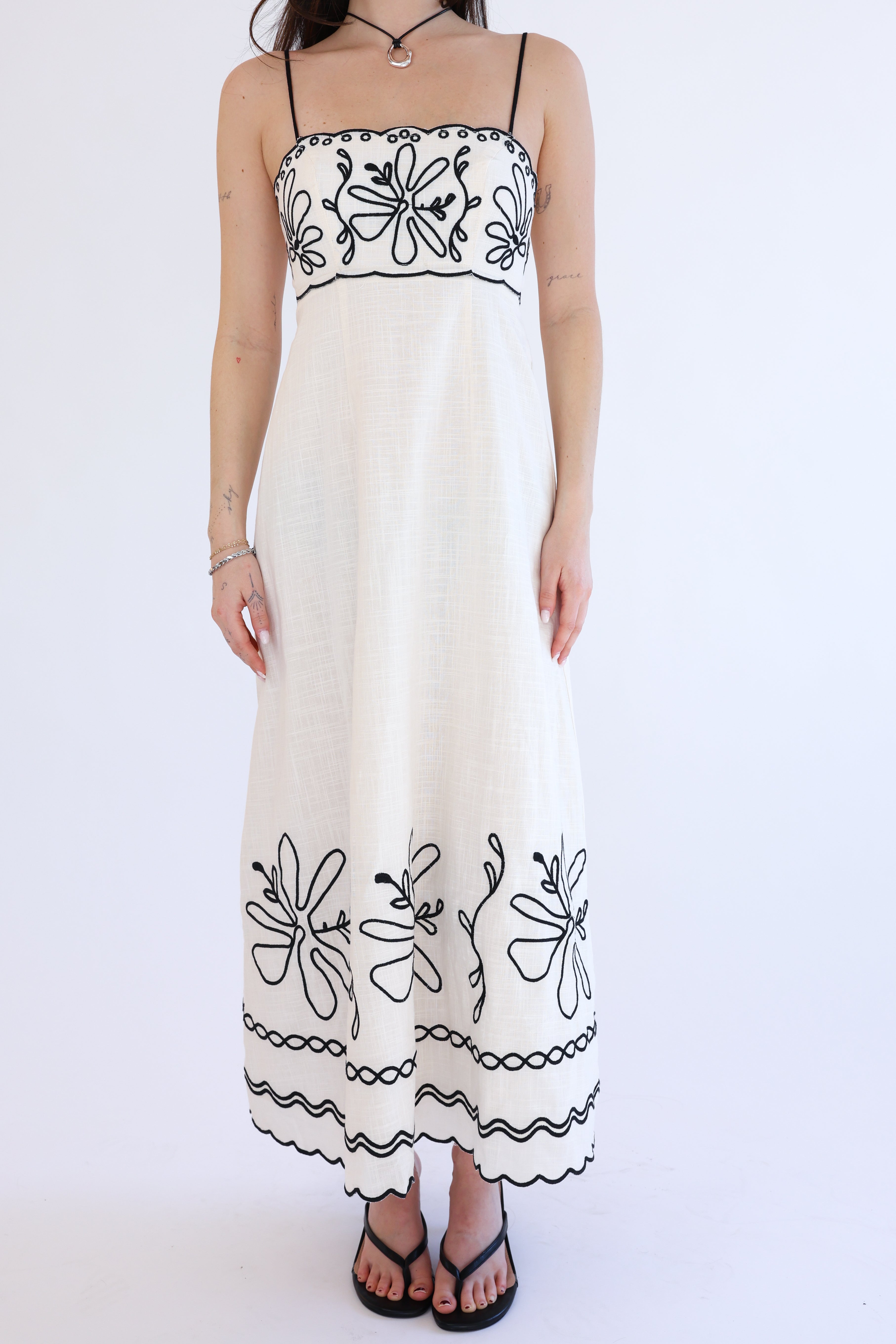 White dress with black floral embroidery on a white background