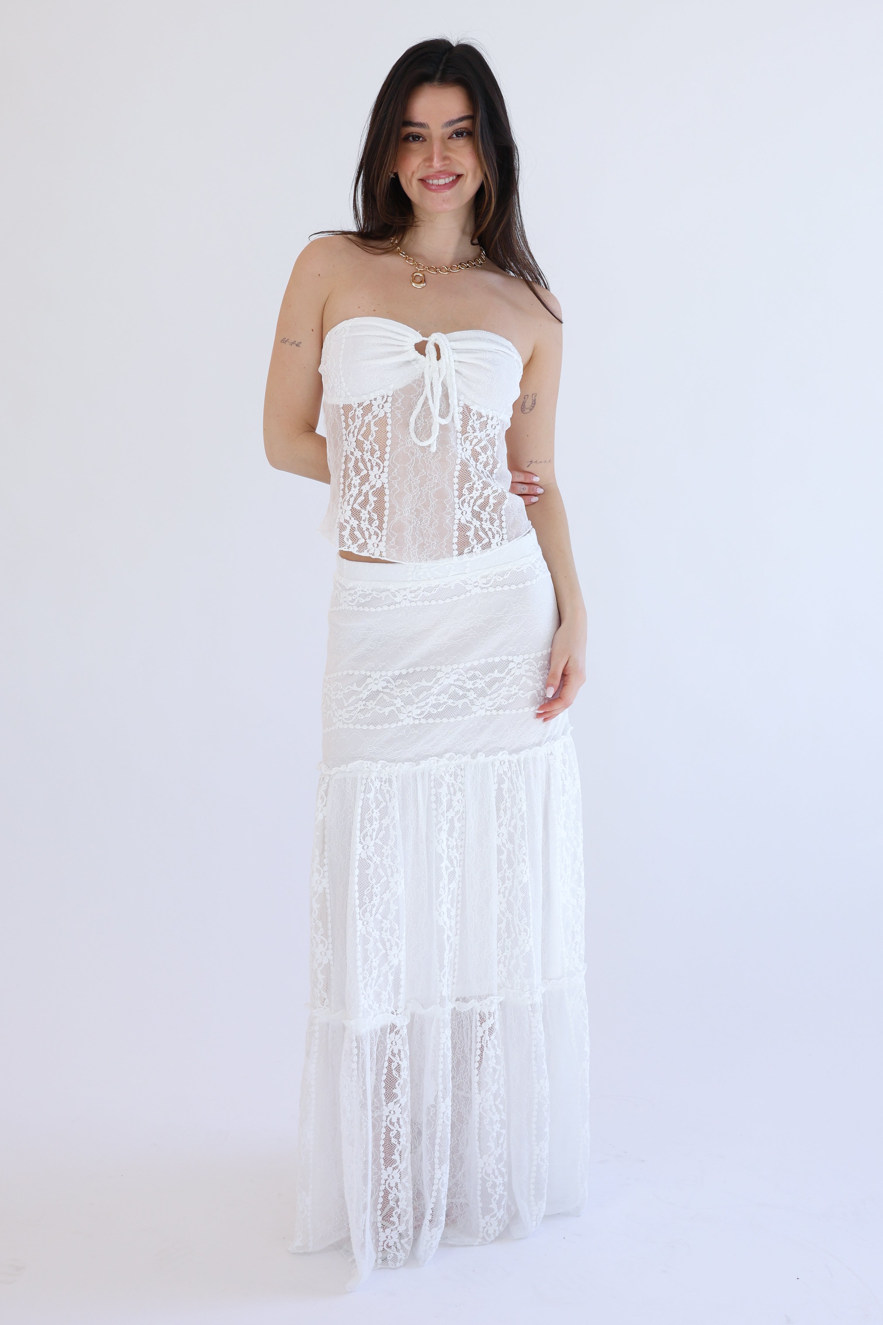 Woman wearing a white lace dress against a white background