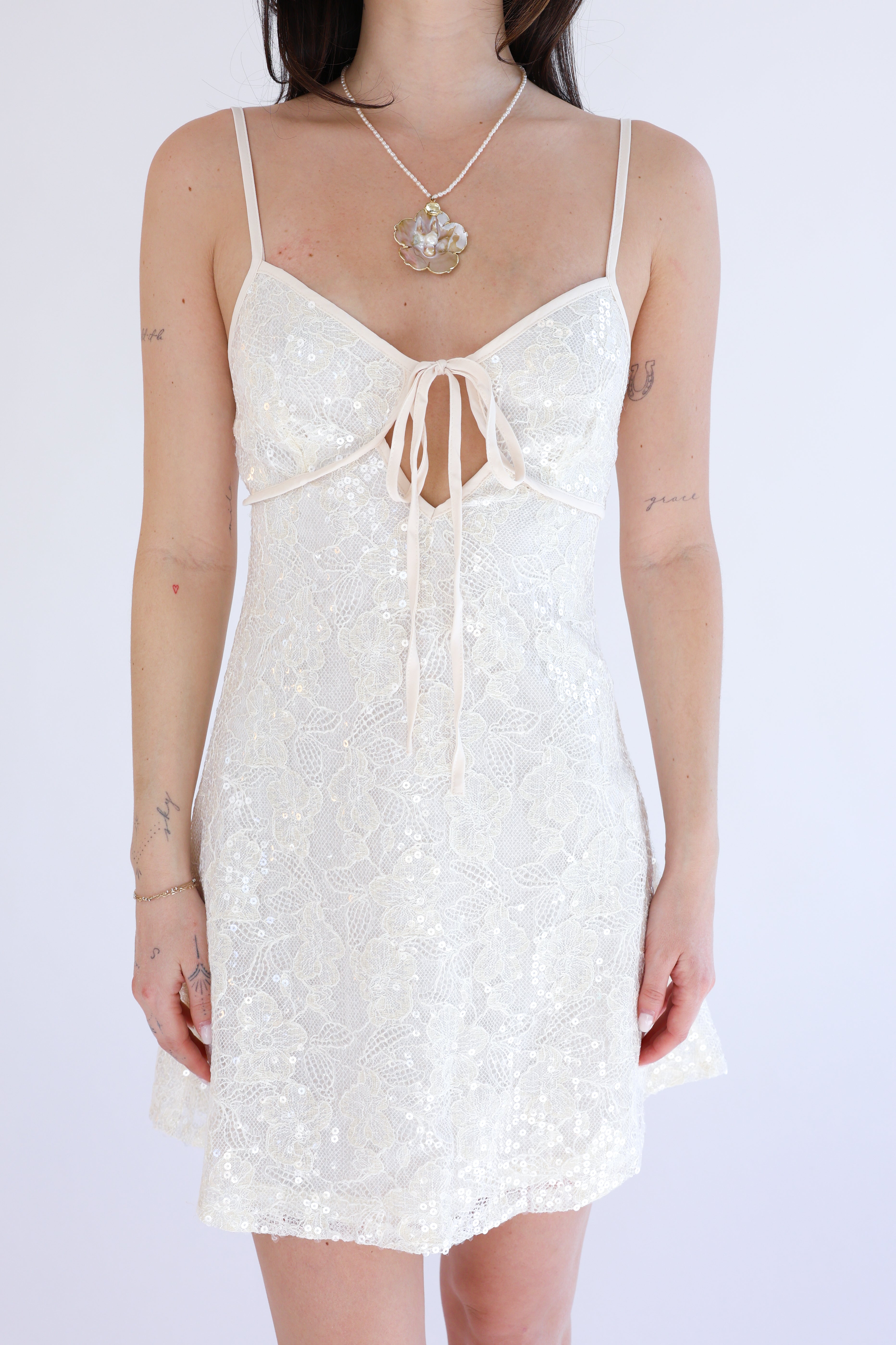 White lace dress worn by a person on a white background