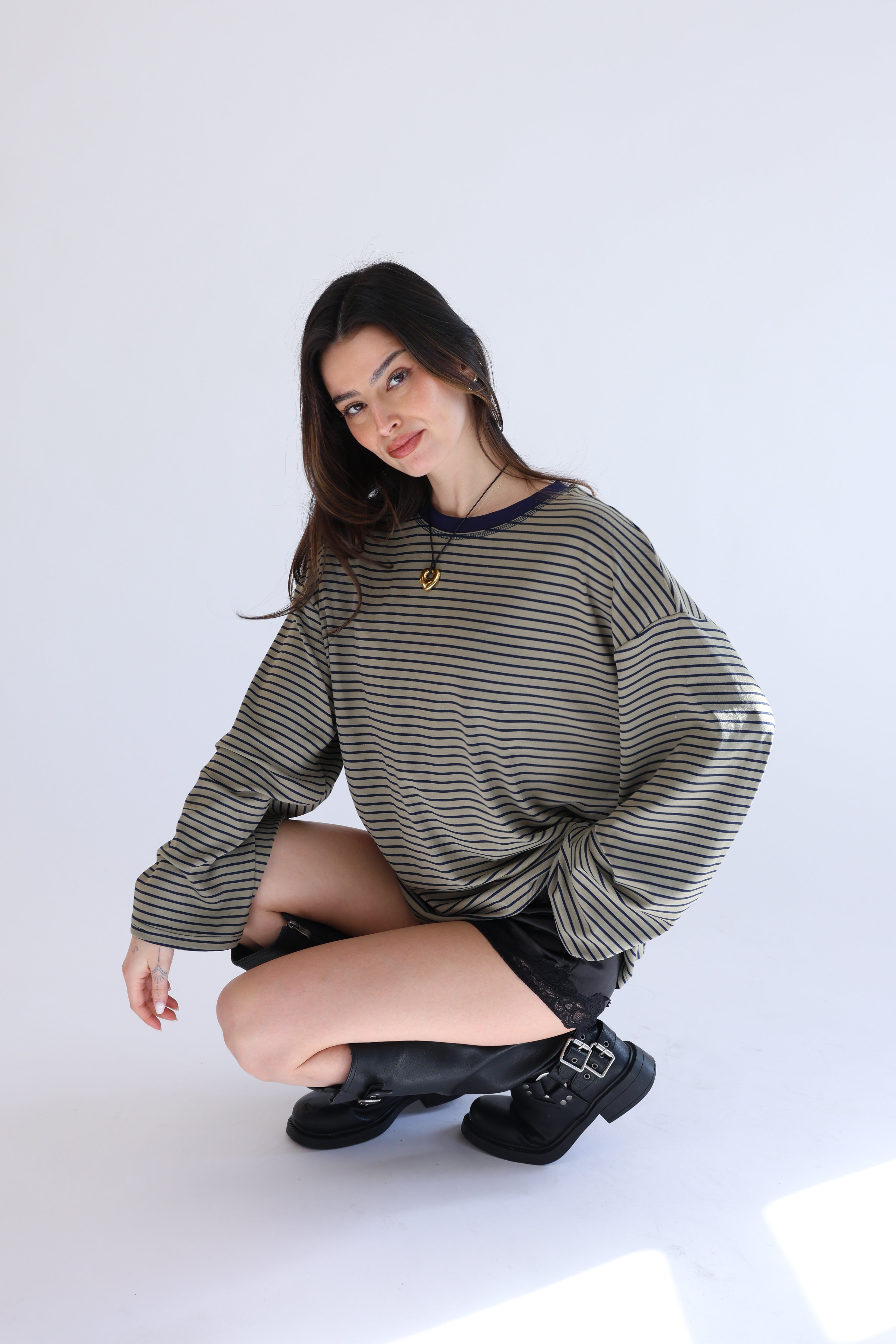 Woman wearing a striped sweater and black skirt on a white background