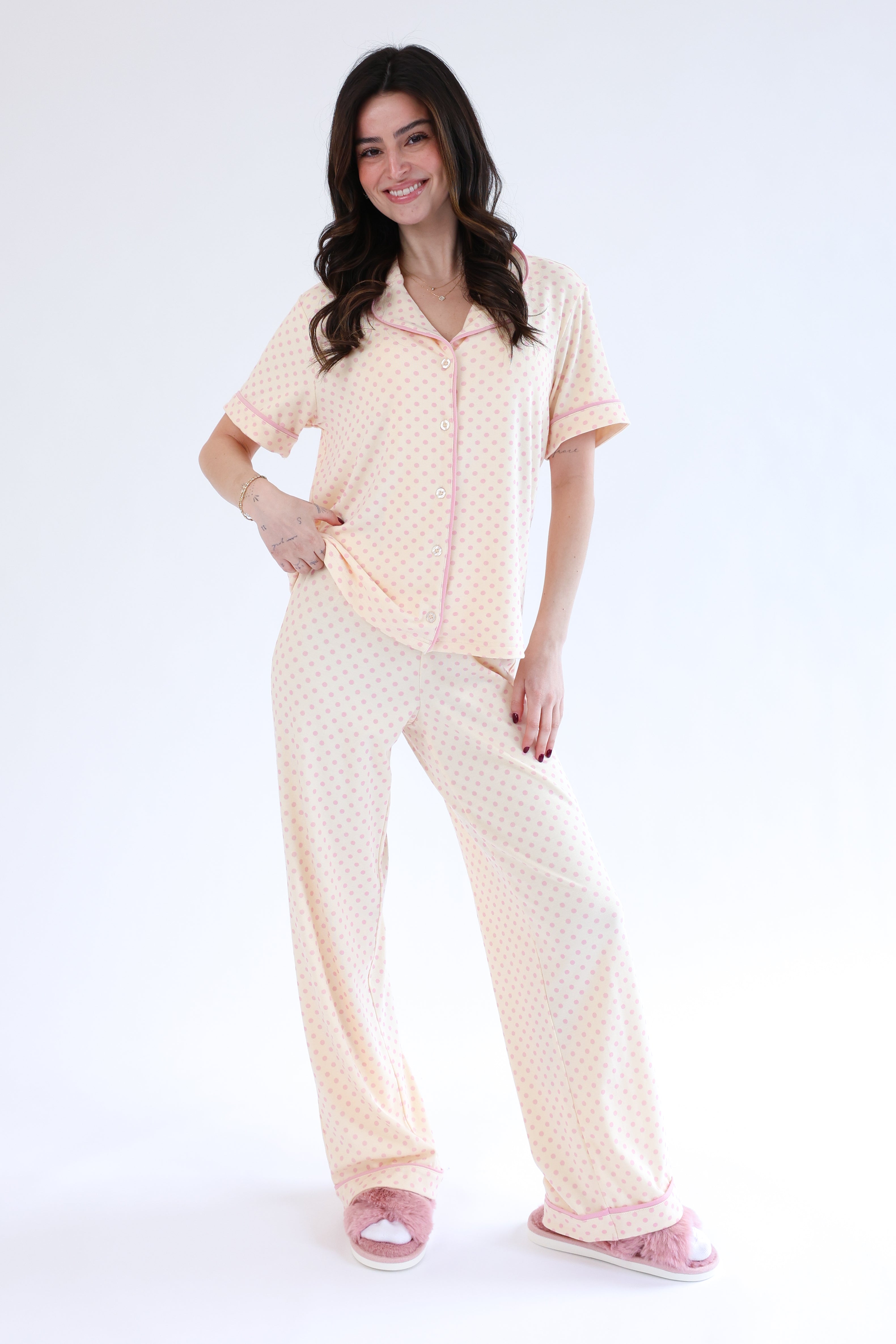 Woman wearing a beige pajama set on a white background