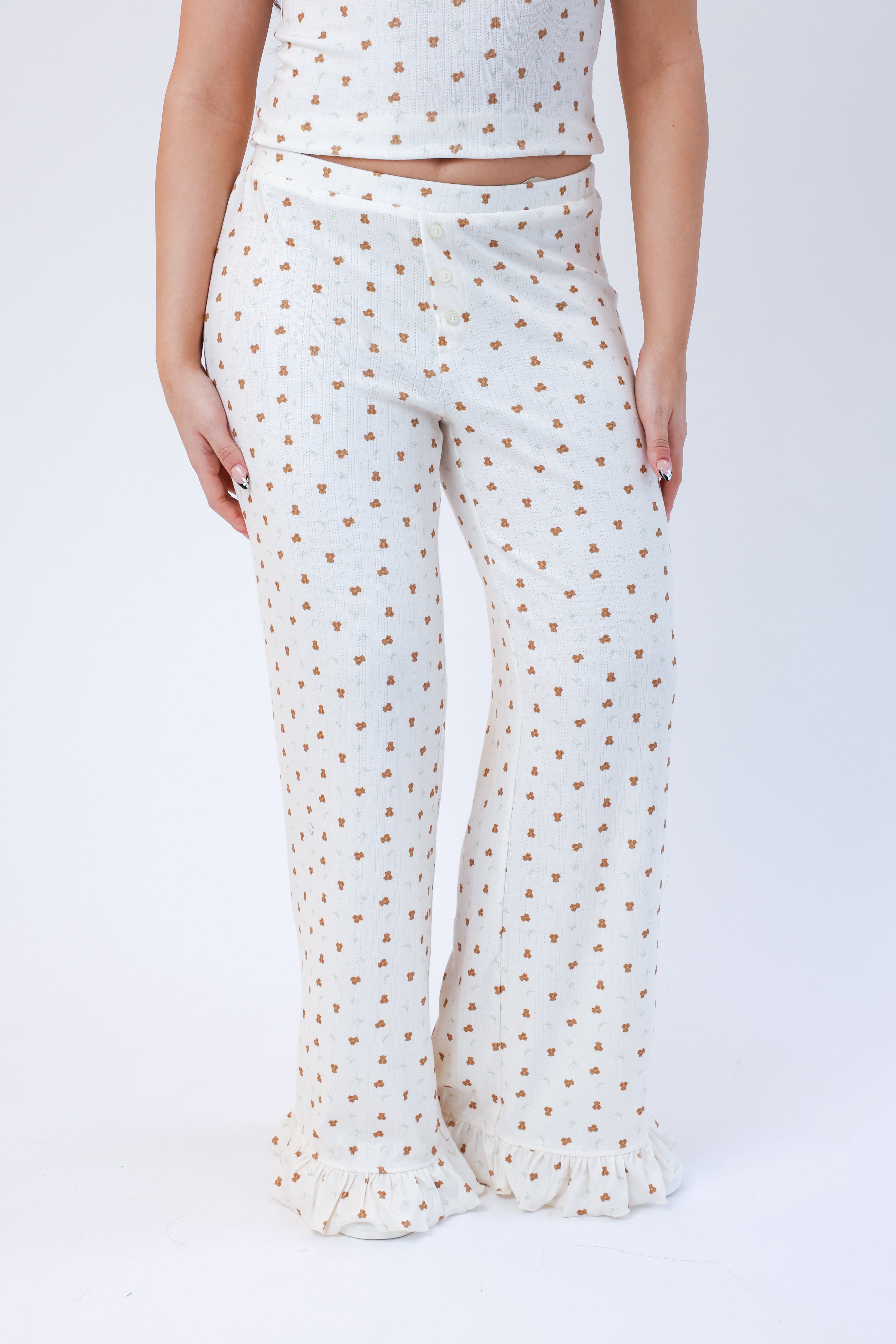 White pants with gold polka dots worn by a person on a white background