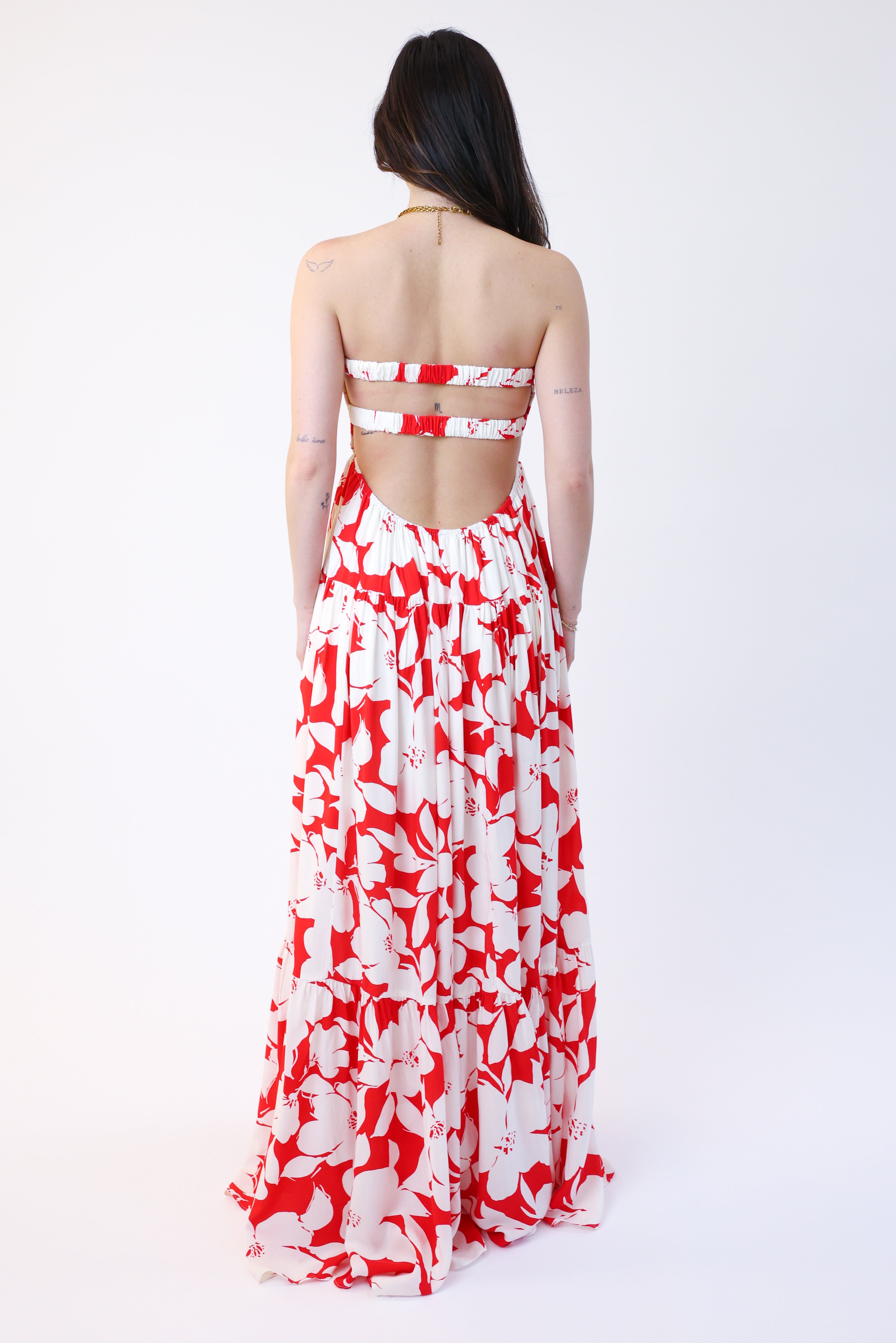 Woman wearing a red and white floral dress on a white background