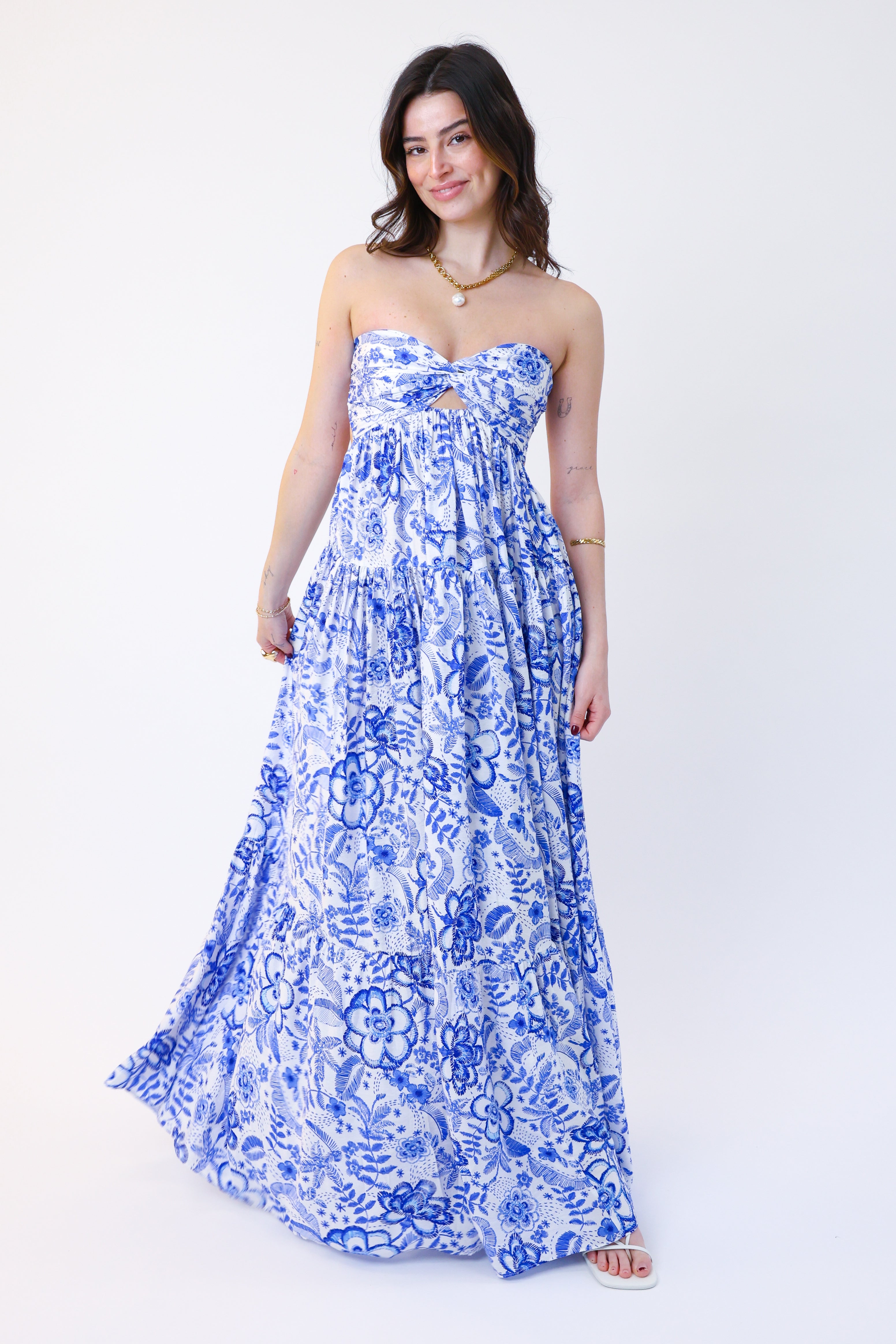 Woman wearing a blue floral strapless dress on a white background