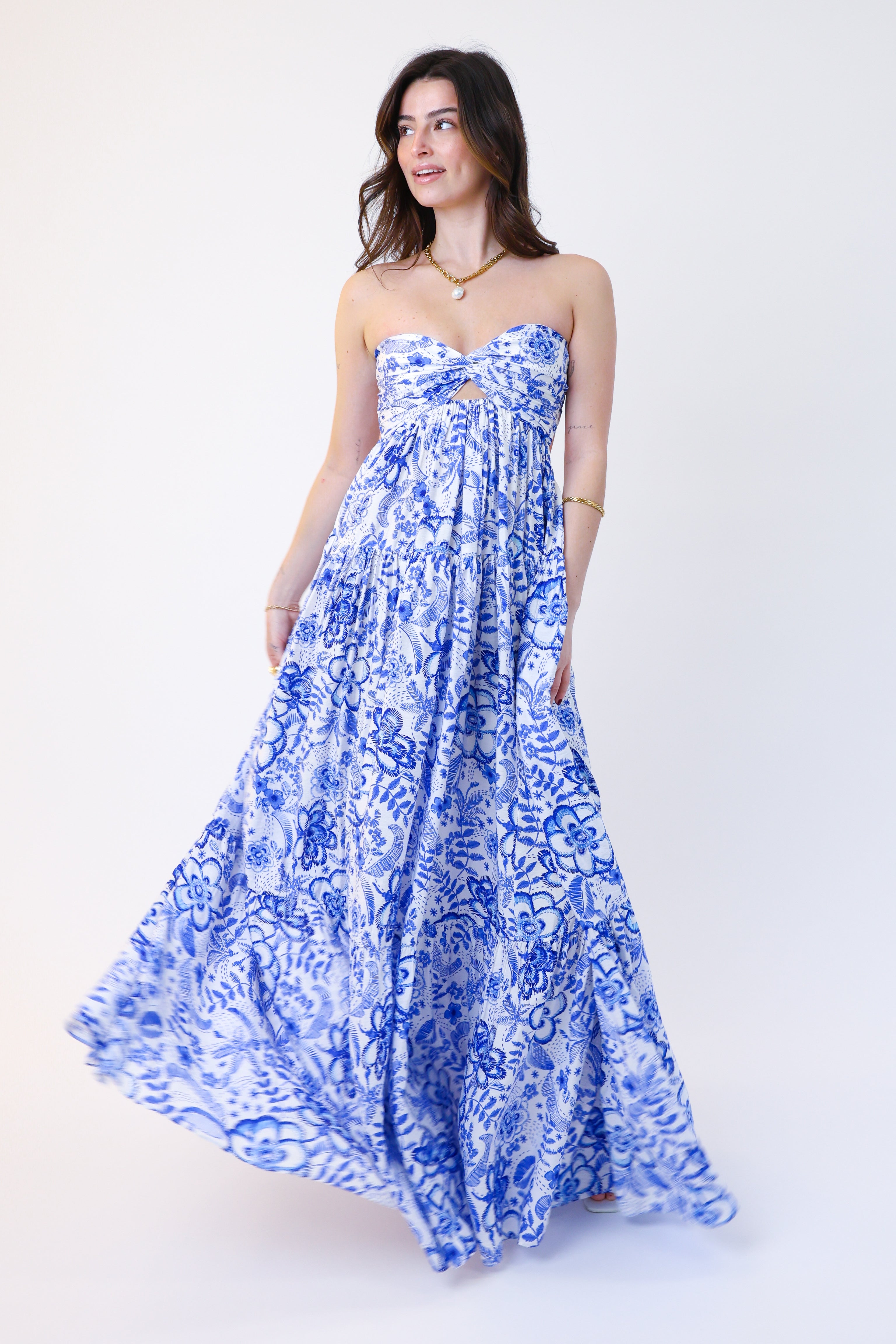 Woman wearing a blue floral strapless dress on a white background