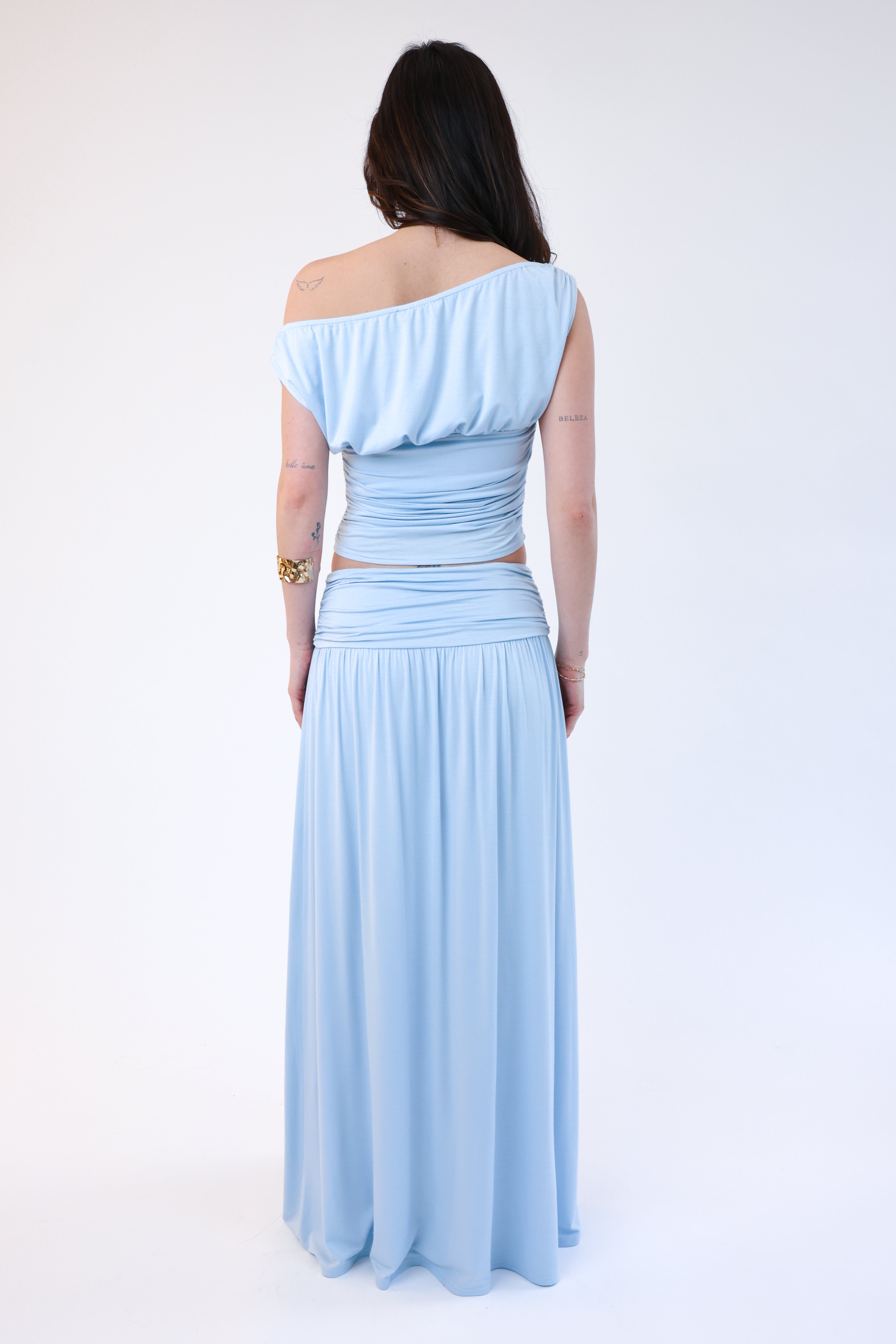 Woman wearing a light blue off-shoulder dress on a white background