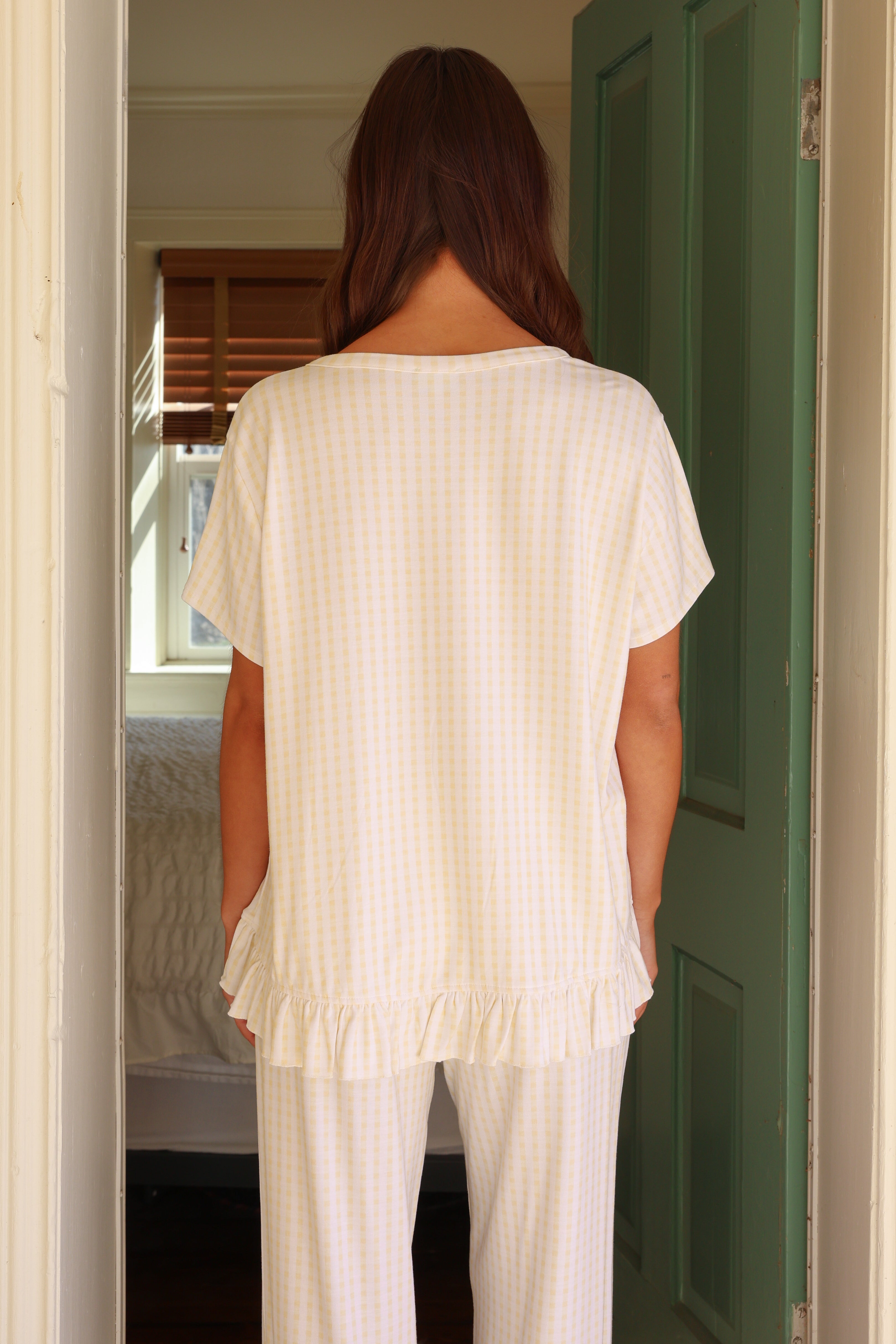 Woman in a white outfit standing in a doorway