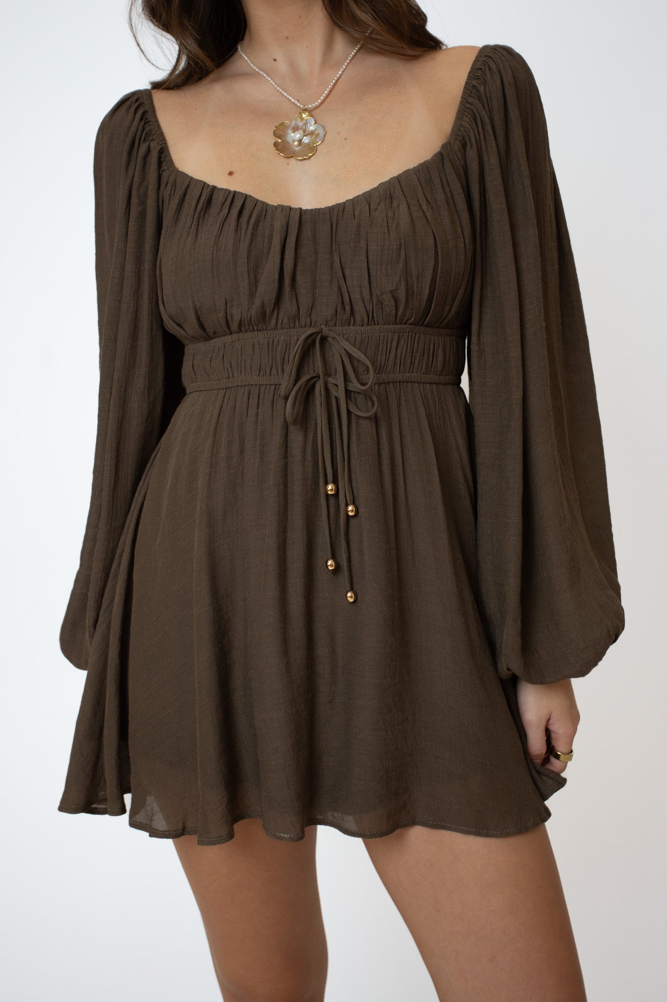 Brown dress with long sleeves on a white background