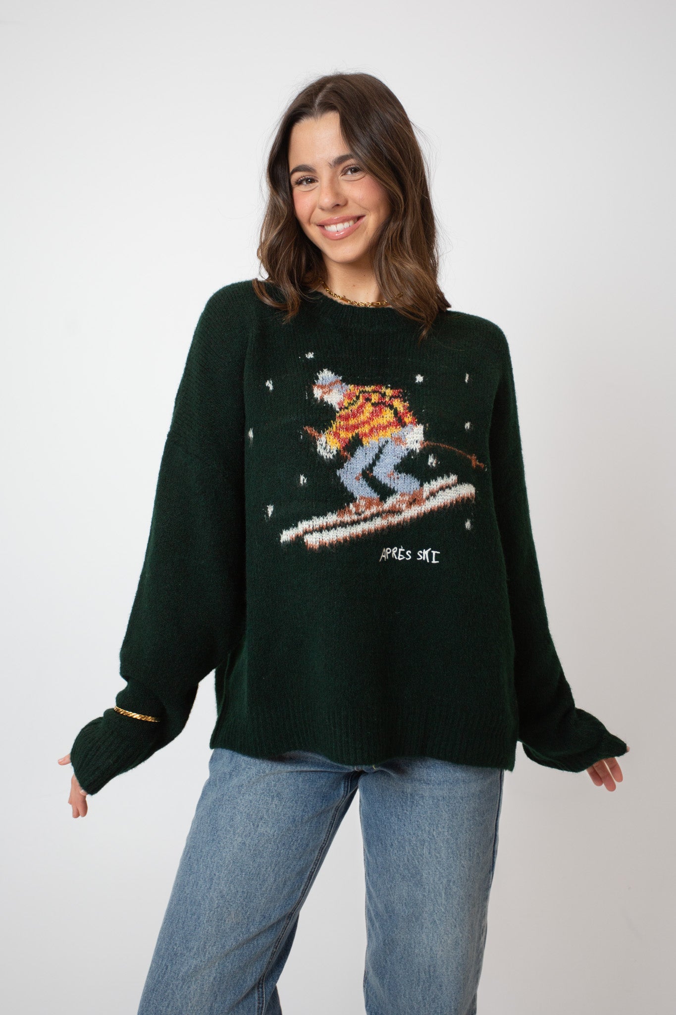 Person wearing a dark green sweater with a pixelated graphic of a skier on a white background