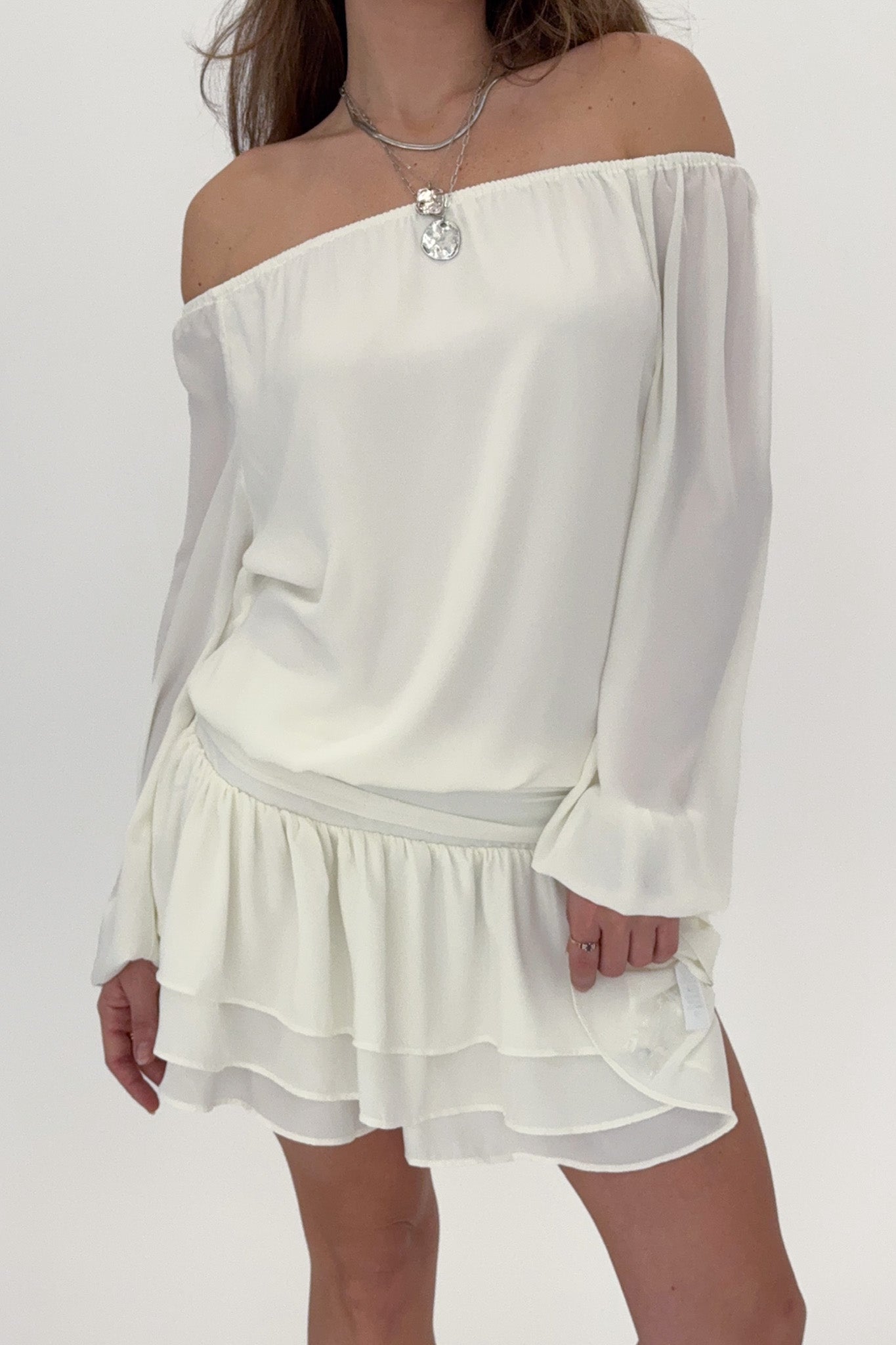 White off-shoulder dress worn by a person on a white background