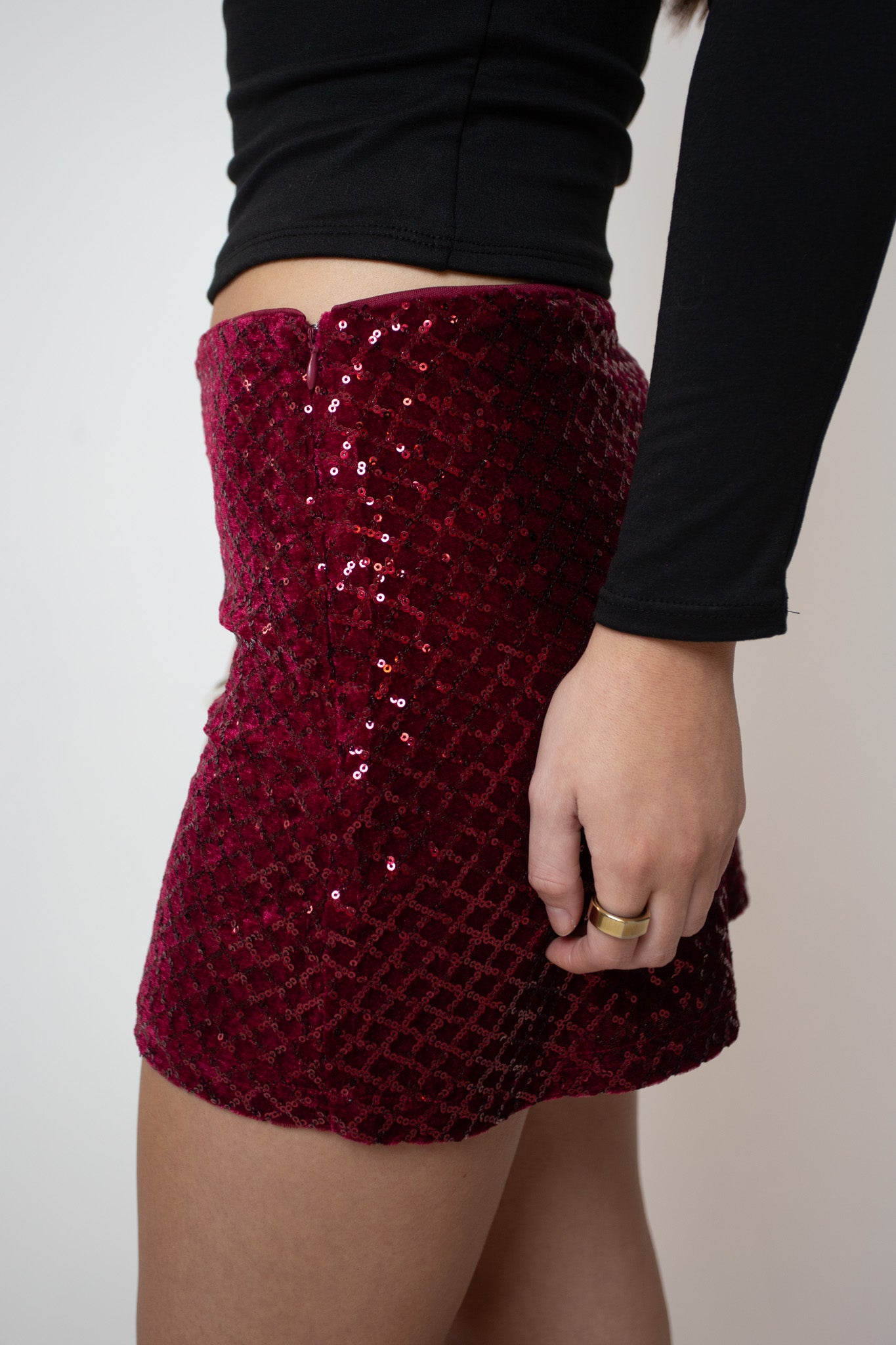 Red sequin skirt worn by a person on a plain background