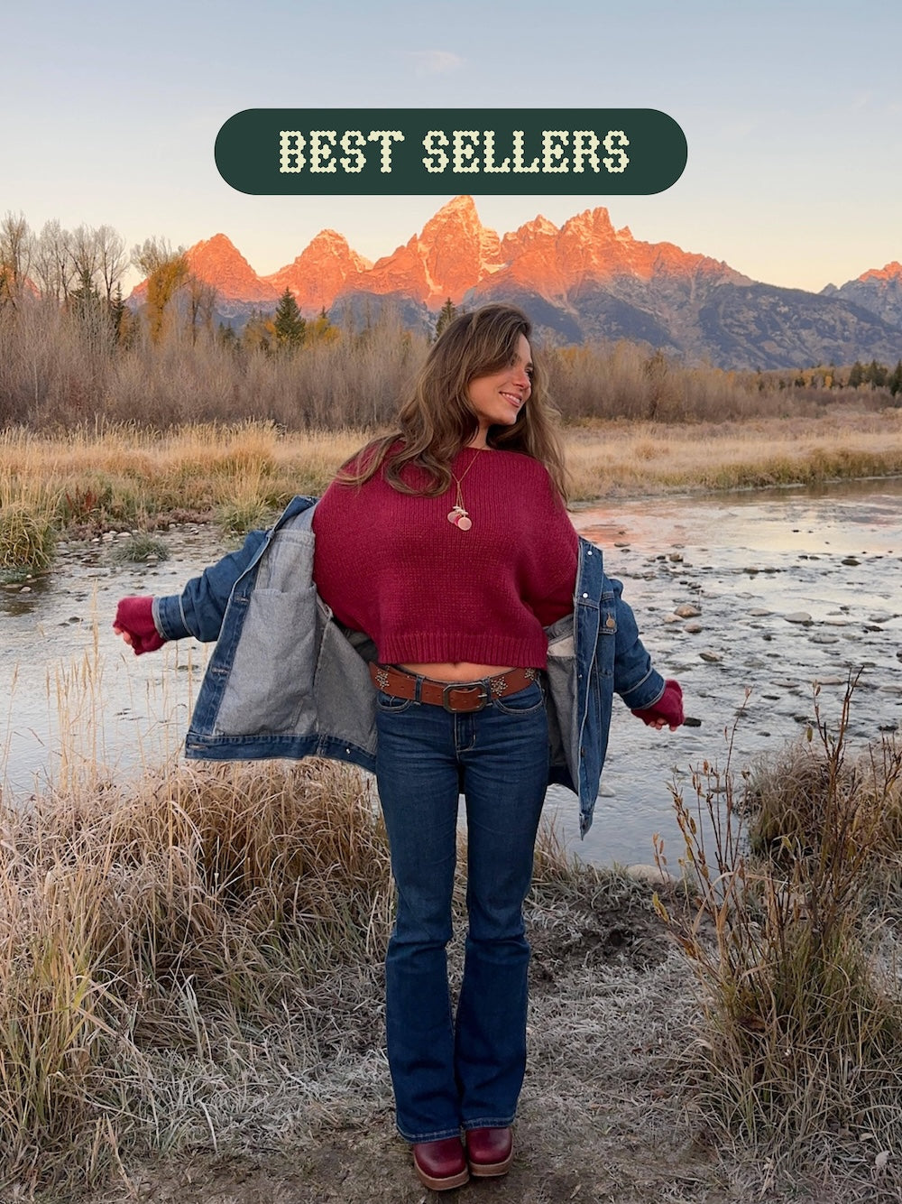 Woman in a red sweater and blue jeans standing in a scenic outdoor setting with mountains in the background, labeled 'Best Sellers'.