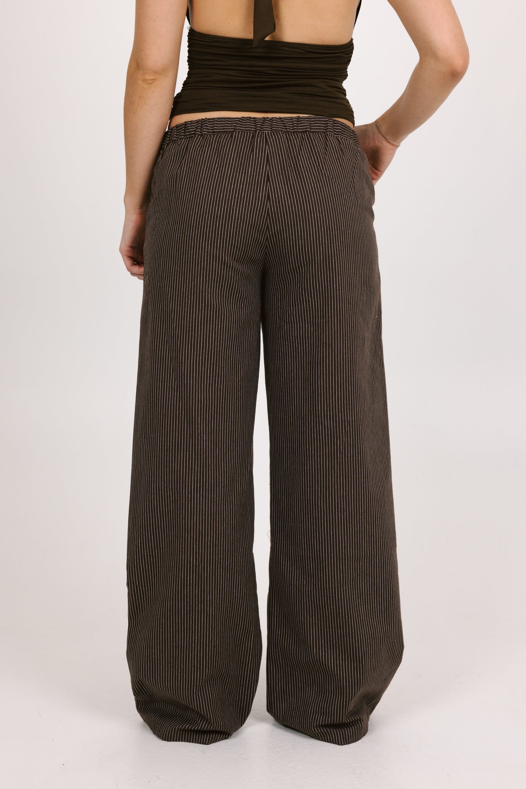 Brown ribbed wide-leg pants worn by a person on a white background