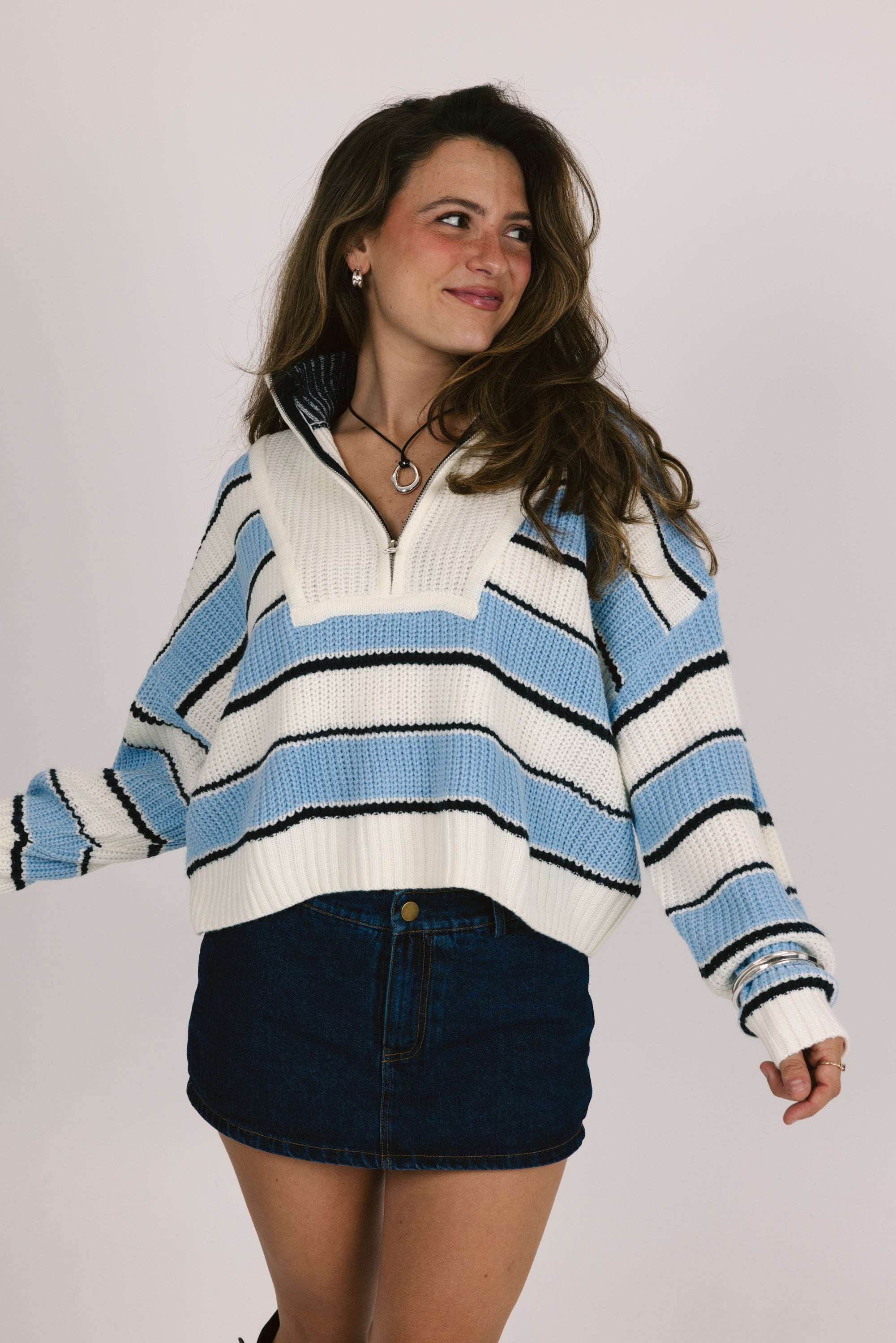 Woman wearing a blue and white striped sweater with a plain background
