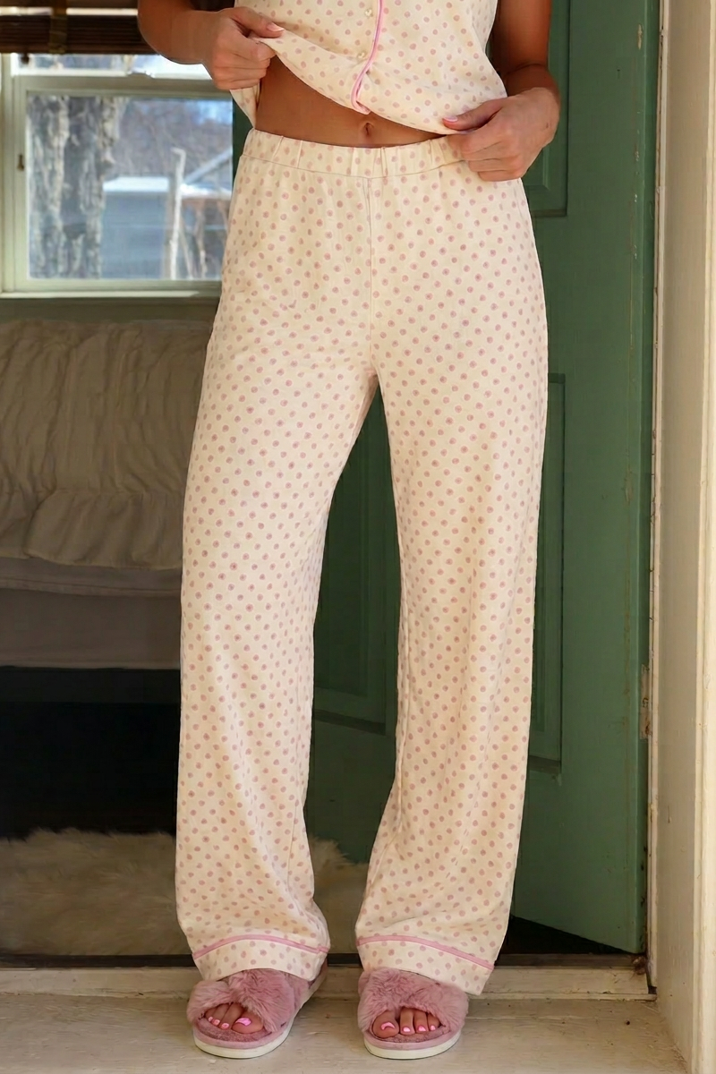 Person wearing a patterned pajama set in a bedroom.